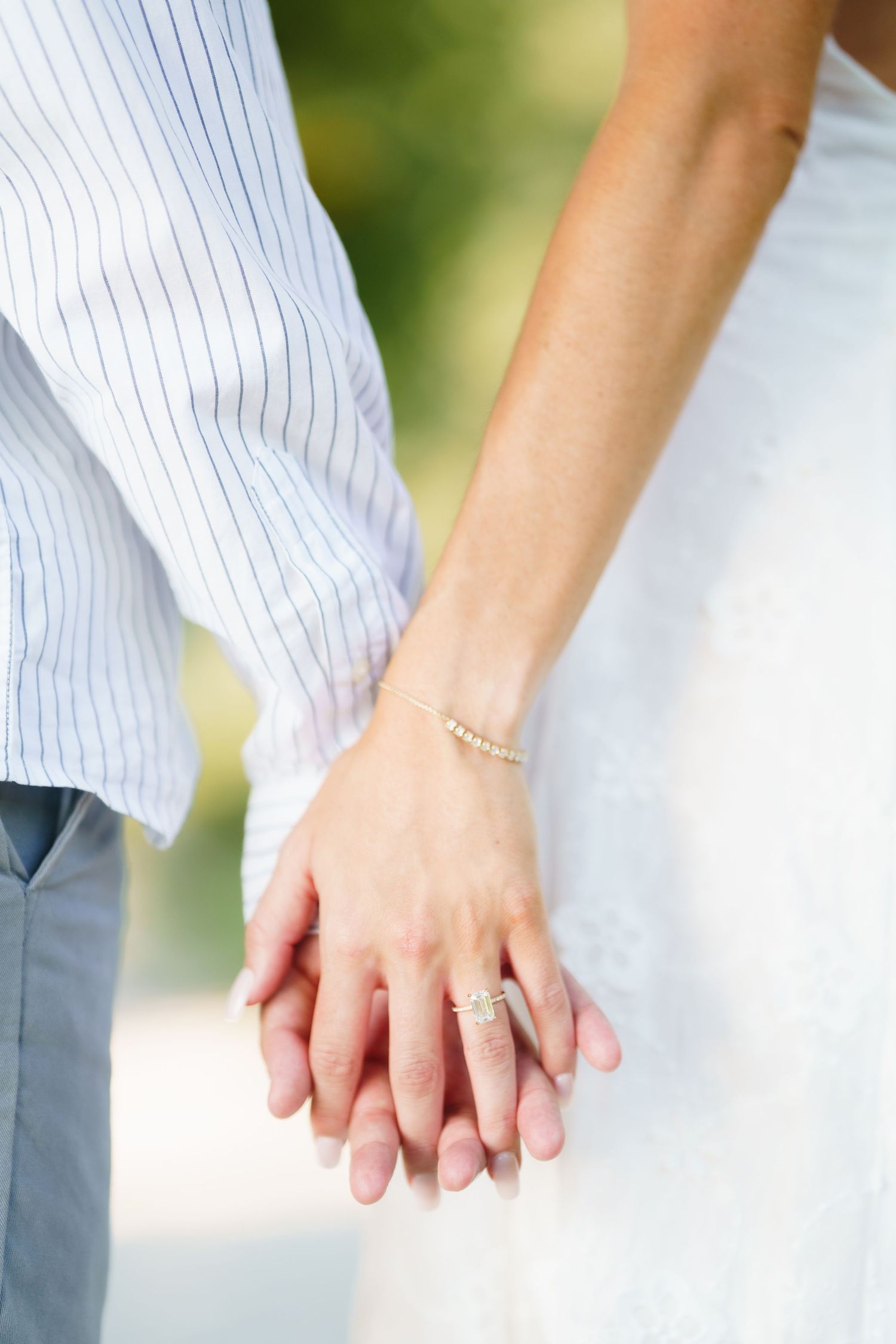 Close-up view of two hands holding each other against a soft blurred background.