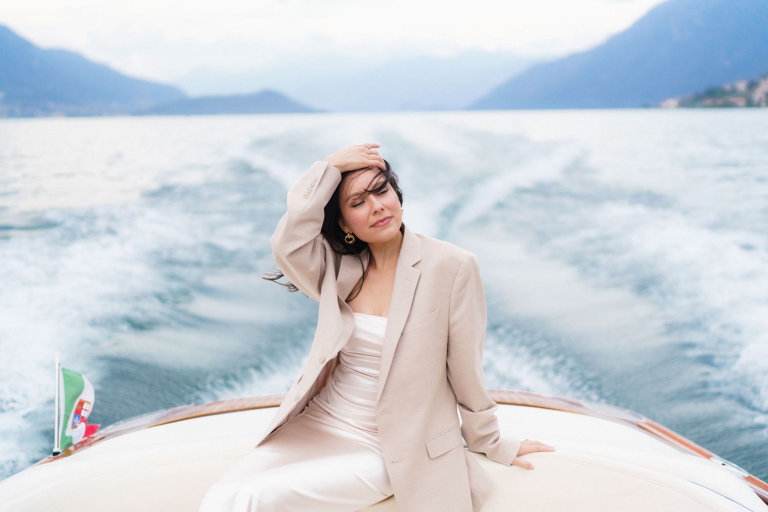 Luxury yacht wake creates white foam patterns on turquoise ocean water during sunny Mediterranean cruise.