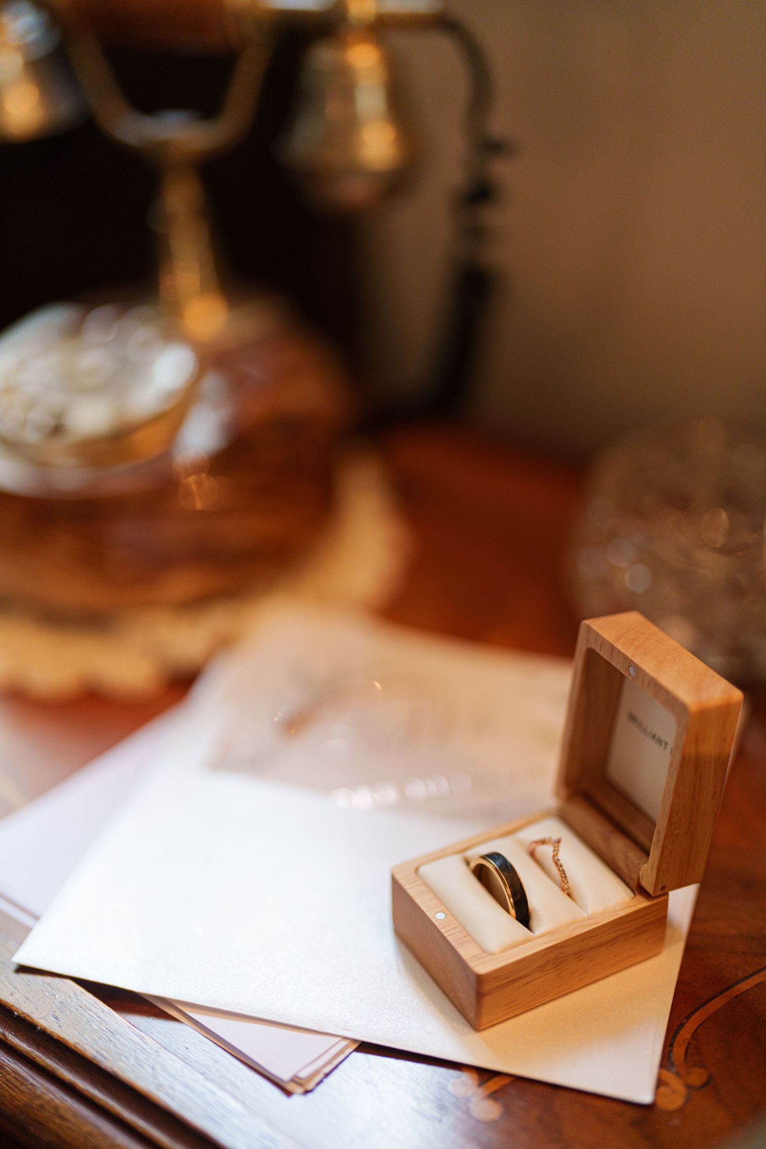Wedding rings in wooden box with vintage decor on antique table.