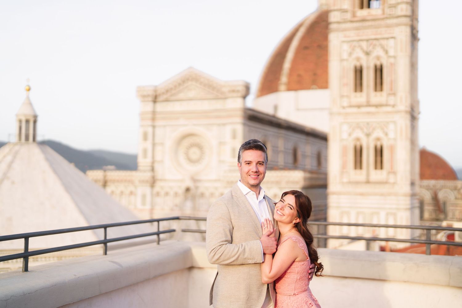 Couple sharing romantic moments against the backdrop of Florence Cathedral in Italy during golden hour.