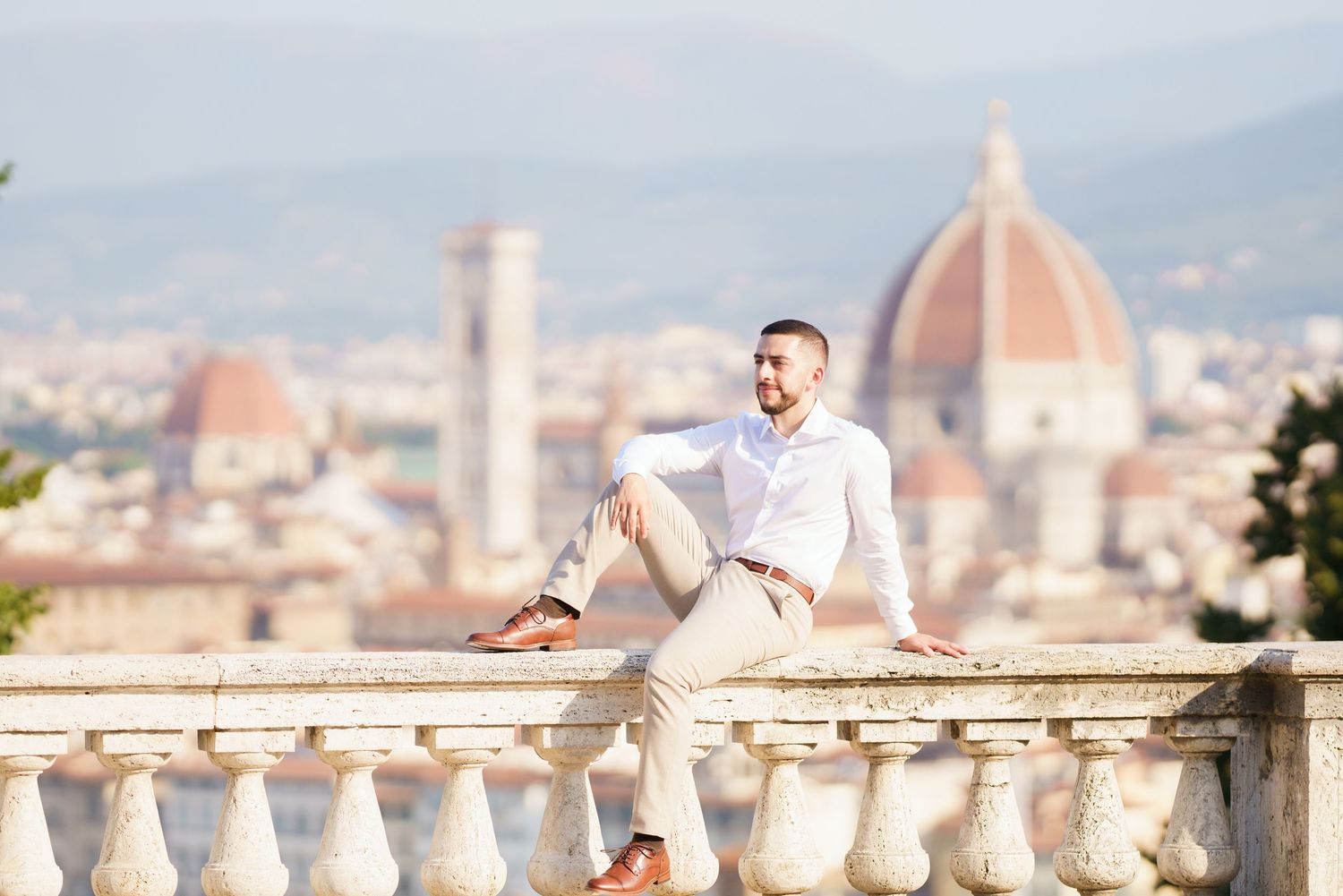 A panoramic view of Florence, Italy with the iconic Duomo cathedral and cityscape visible from Piazzale Michelangelo.