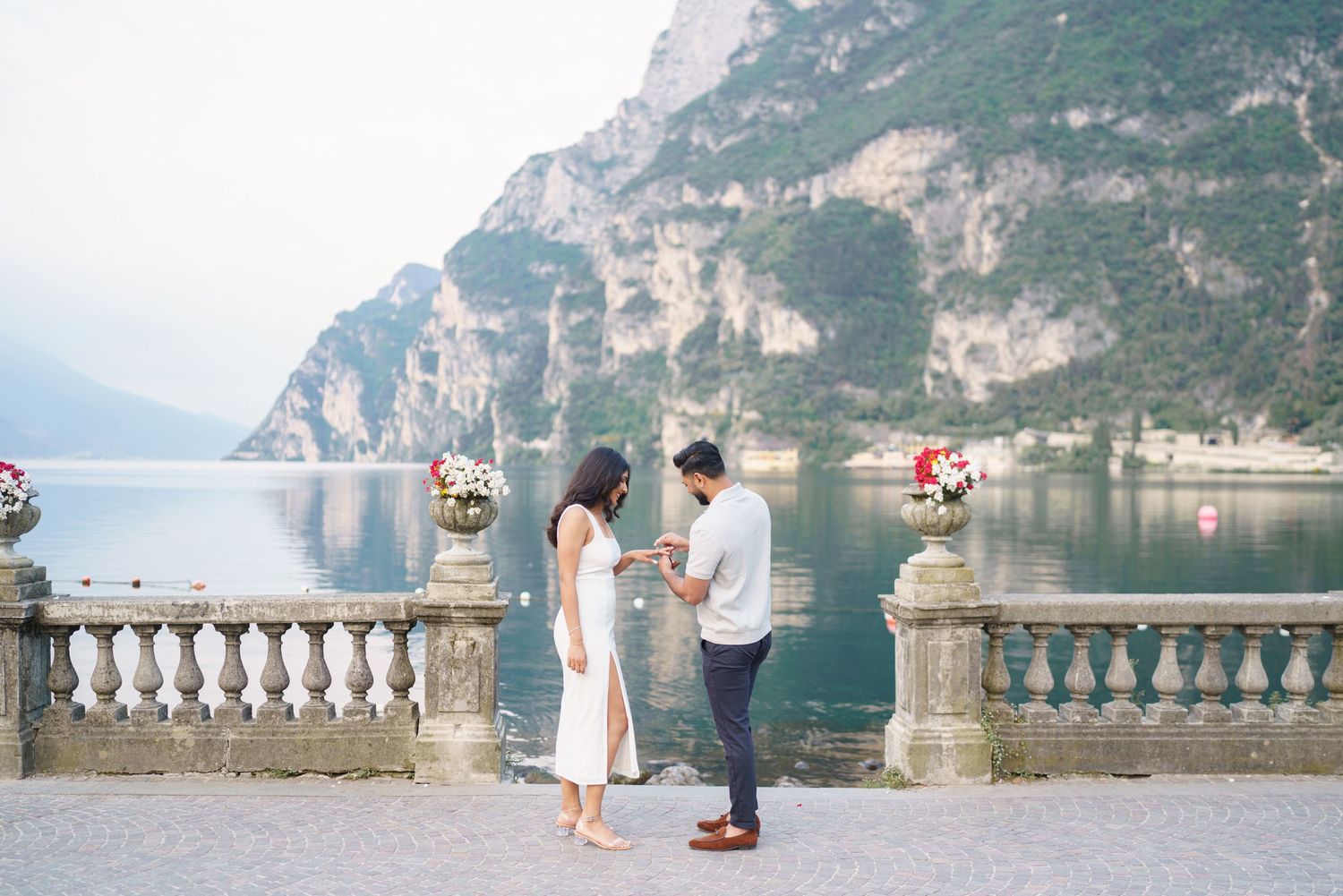 A romantic lakeside proposal moment with scenic mountain views and turquoise waters in Lake Garda, Italy.