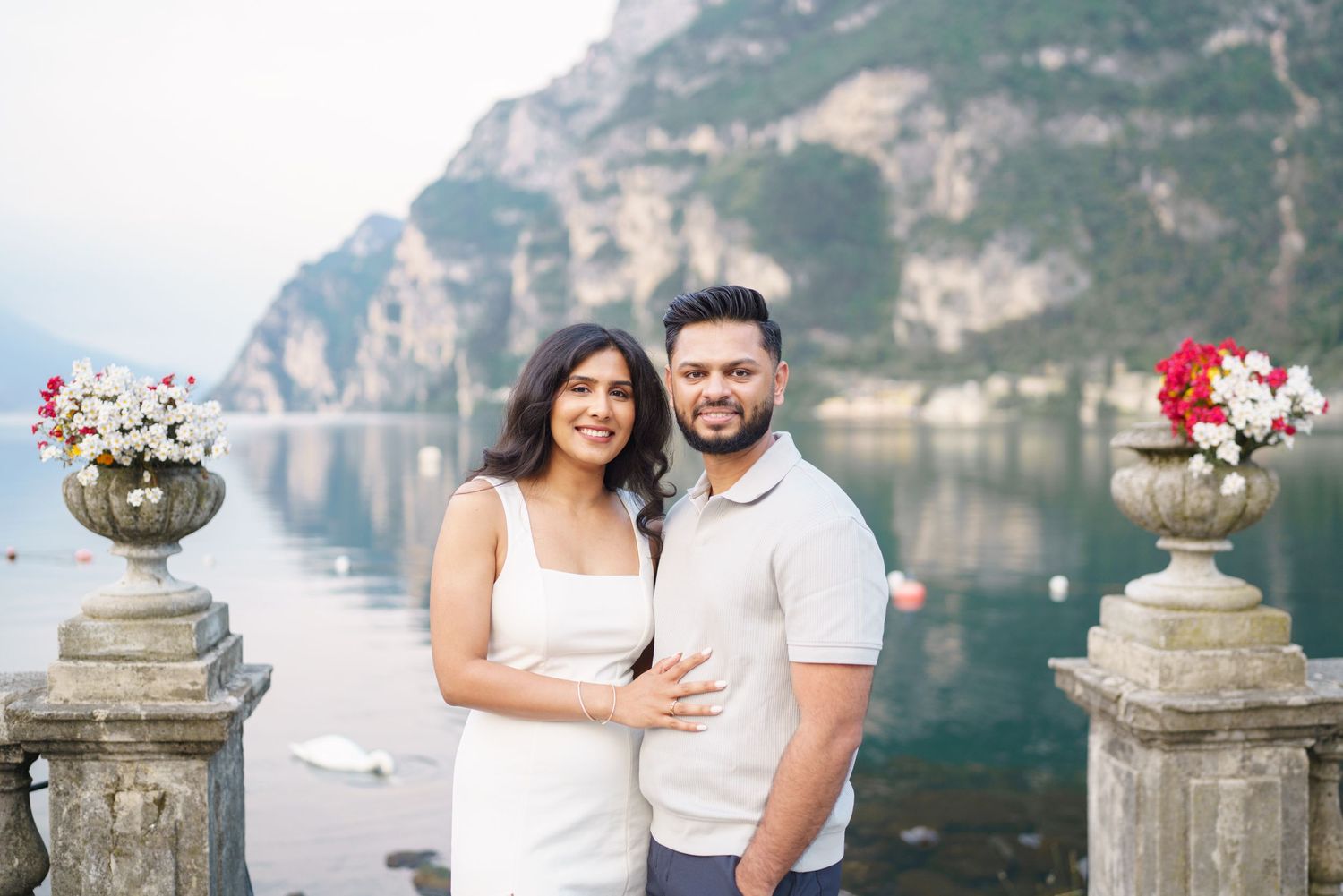 A couple poses for romantic engagement photos along the scenic Amalfi Coast with dramatic cliffs in the background.