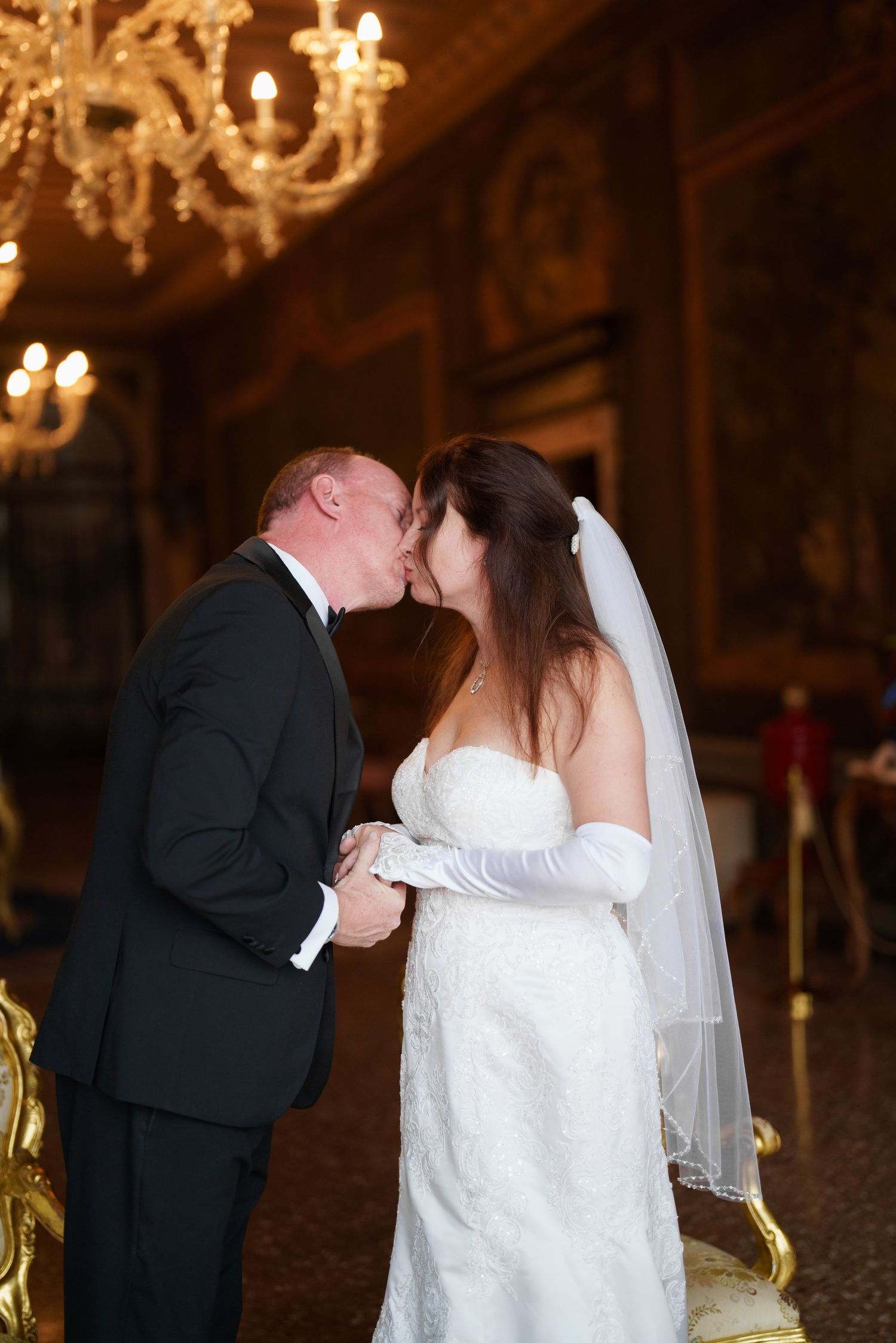 A romantic wedding kiss sequence captured in three frames under elegant crystal chandeliers.