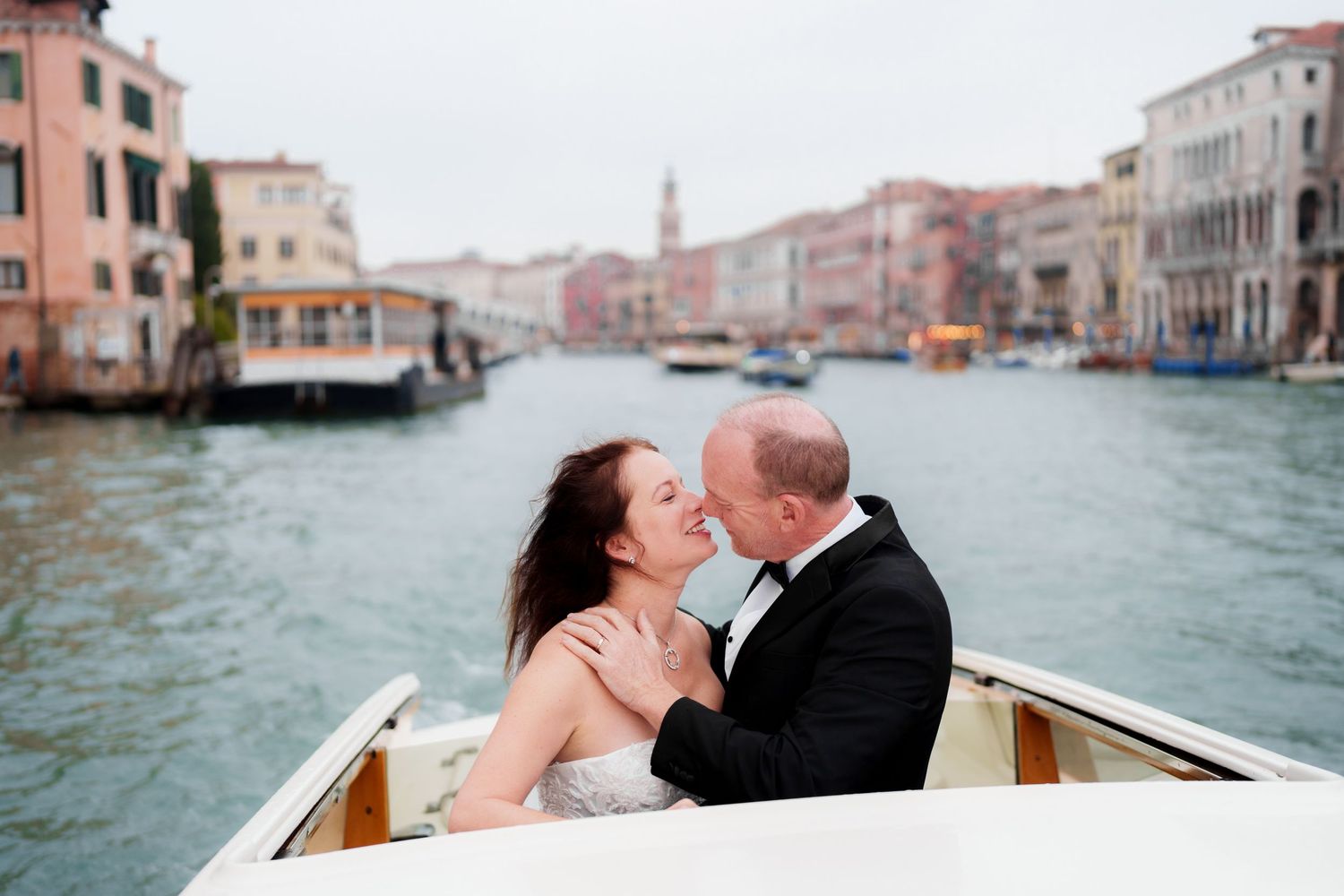 A couple shares an intimate moment while riding in a gondola through the canals of Venice, Italy.