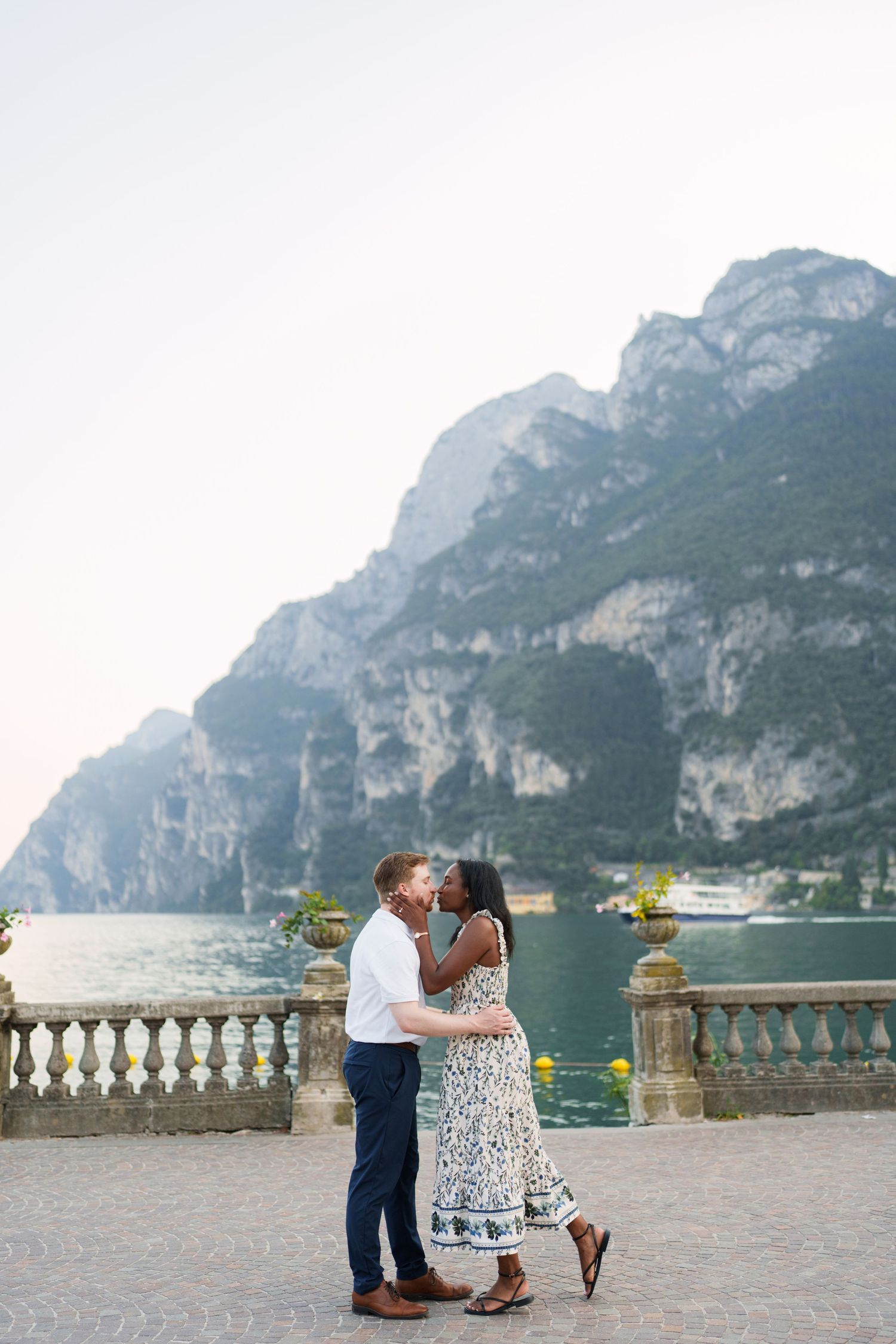 Engaged couple embracing beside Lake Garda during their Riva del Garda proposal session