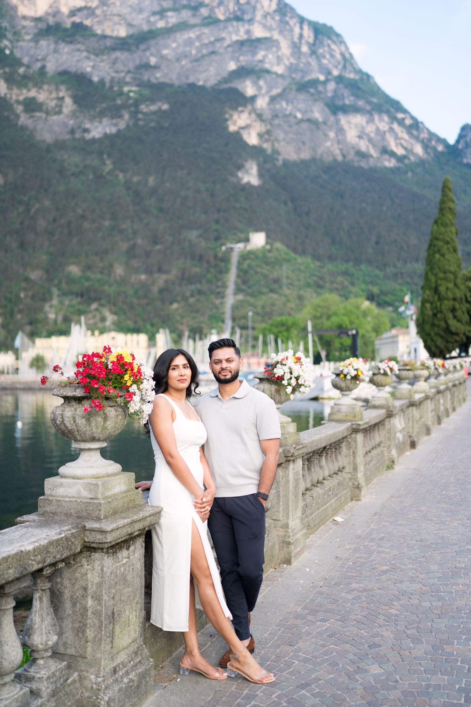 Couple enjoying a romantic stroll along Lake Garda's scenic waterfront promenade in Riva del Garda, Italy.