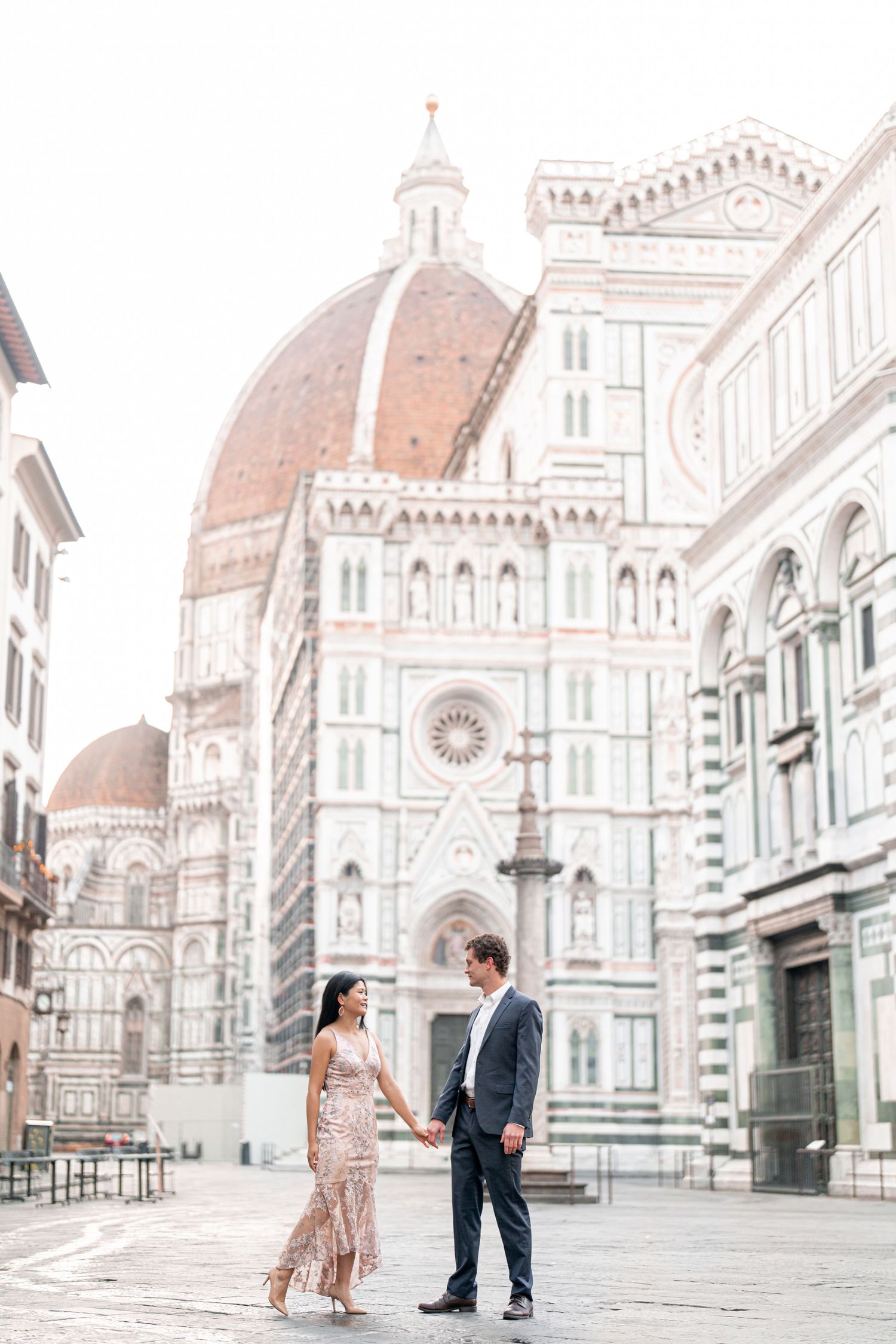 Romantic couple engagement photo session in front of Florence Cathedral with multiple poses in the early morning light.