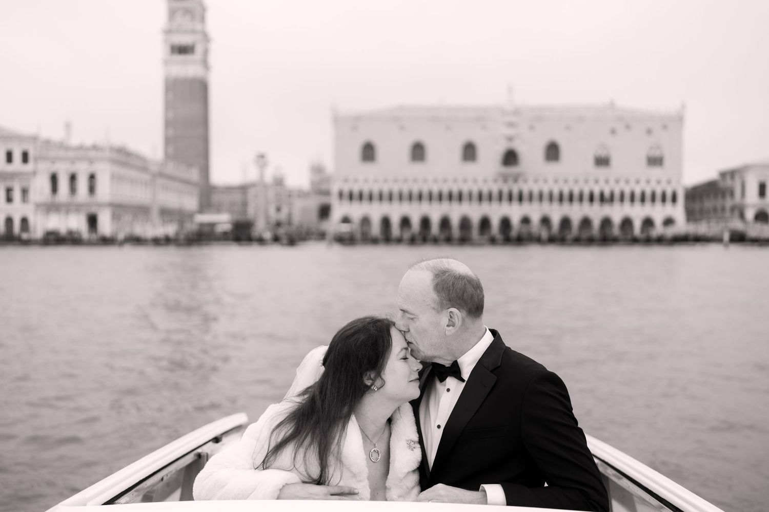 A romantic black and white wedding photo series showing intimate moments between a couple in Venice, Italy.