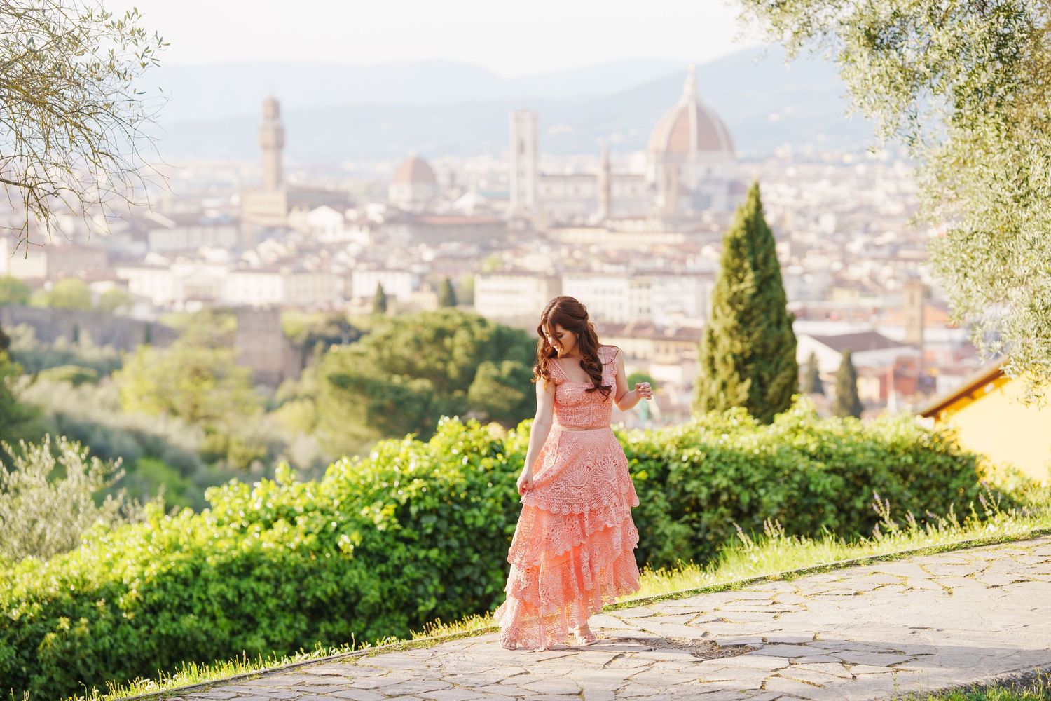 A scenic view of Florence, Italy with the iconic Duomo cathedral dome visible in the distance during golden hour.