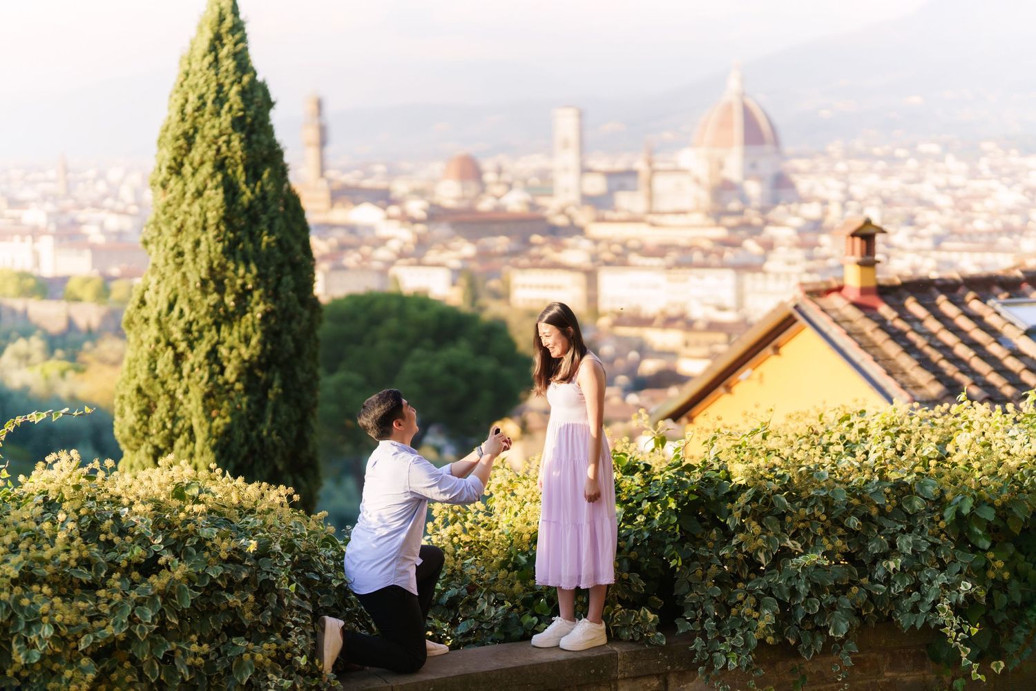 A romantic proposal moment overlooking the scenic cityscape of Florence, Italy with the Duomo cathedral visible in the distance.