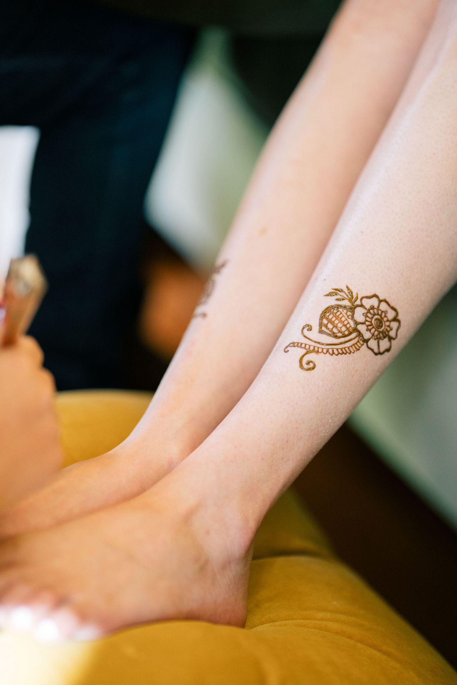 Close-up shots of delicate henna artwork on skin against dark background.
