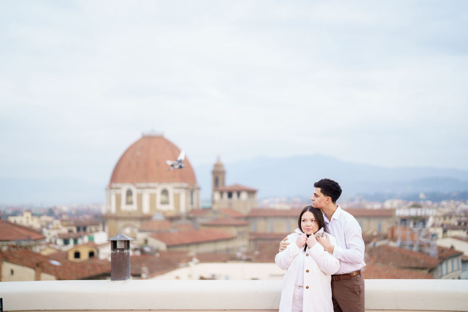 Couple enjoying view of Florence's historic architecture from scenic overlook.