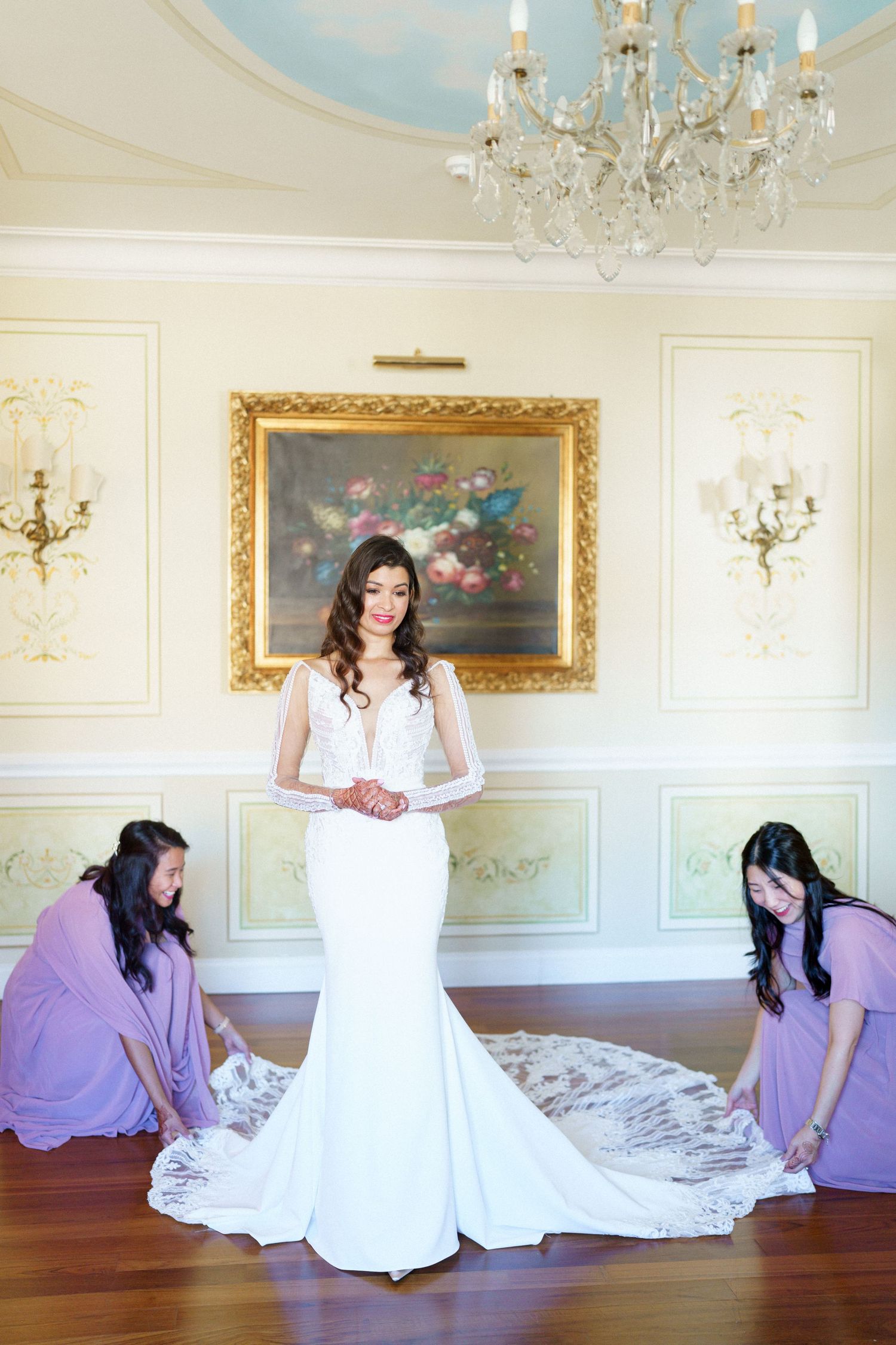 Wedding dress preparation sequence in elegant room with chandelier and ornate gold frames.