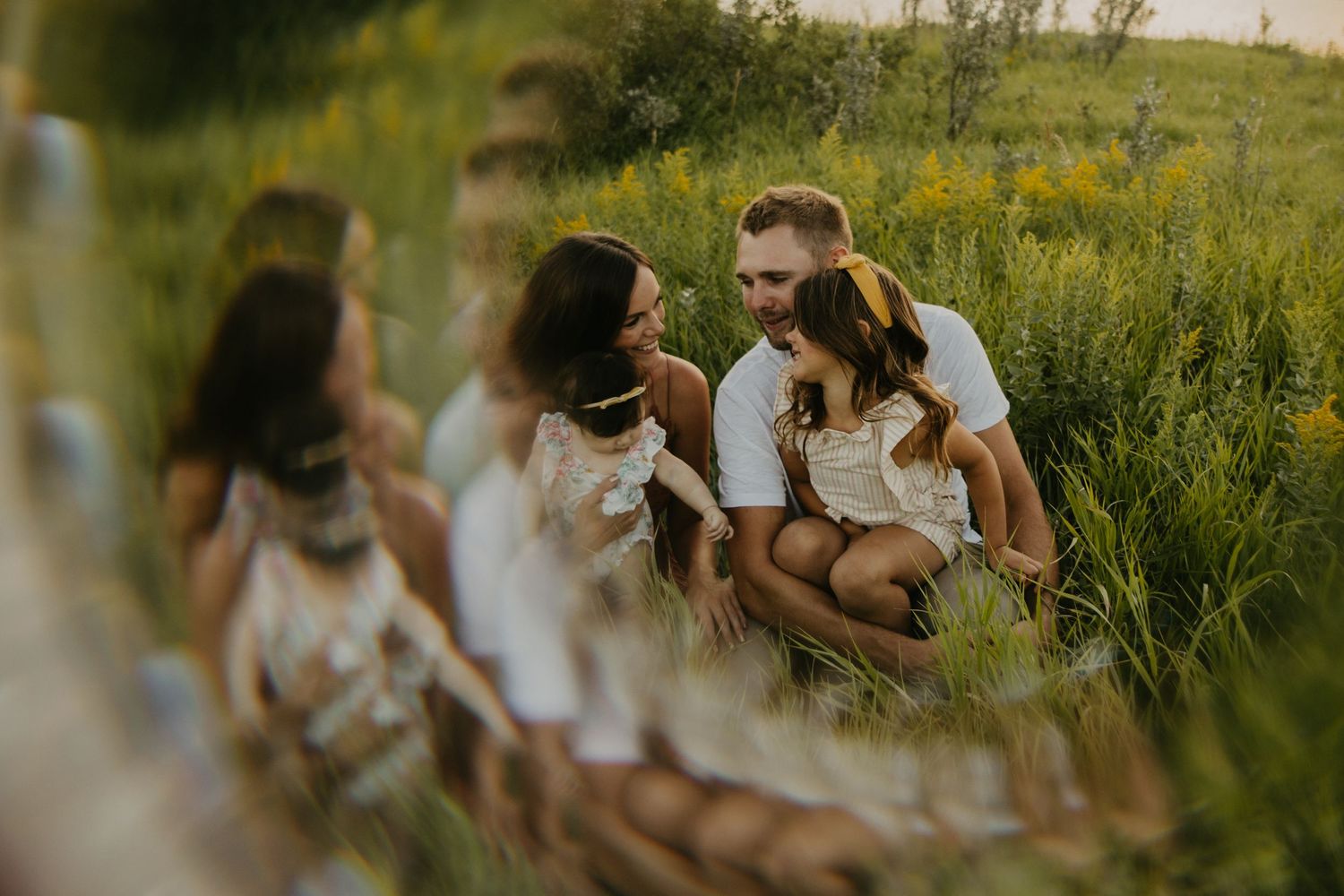 A loving family moment captured in golden wildflowers at sunset.