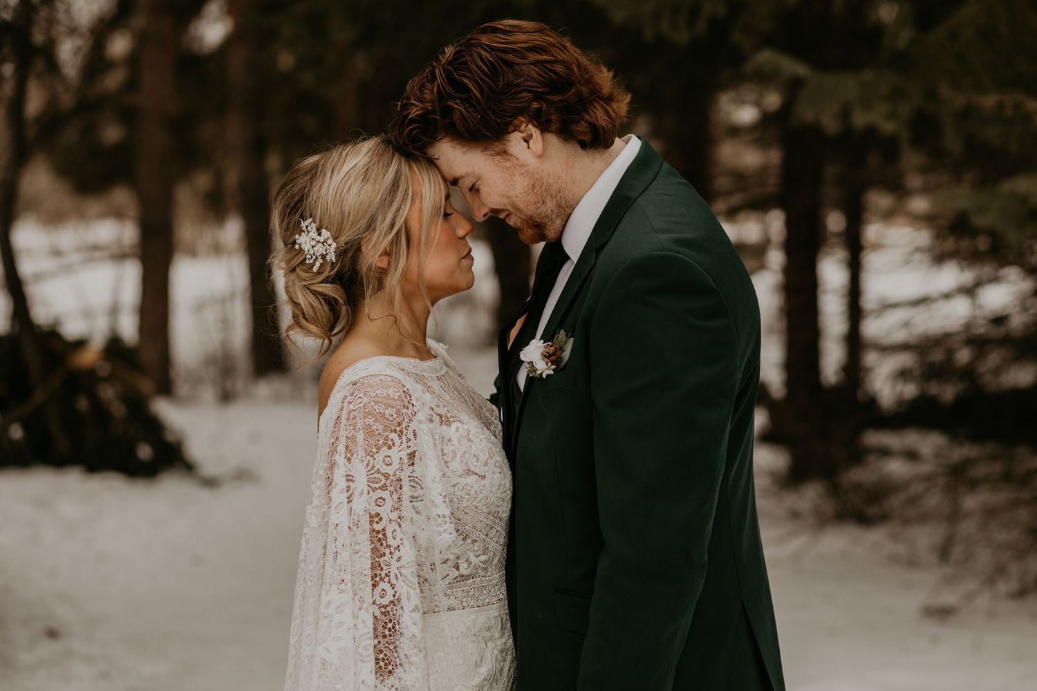 Intimate close-up of a couple sharing a tender moment in a snowy forest setting.