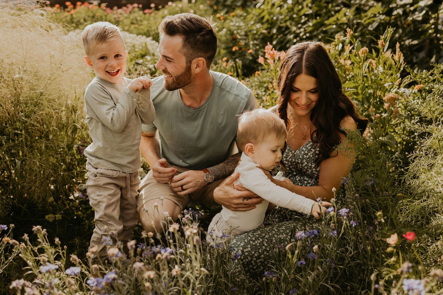 A family shares a joyful moment together in a wildflower meadow during golden hour.