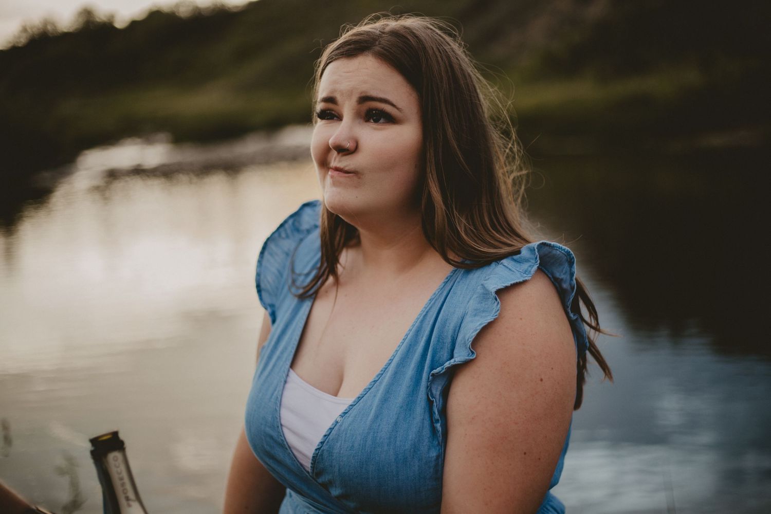 A portrait at golden hour by a serene lake with soft natural lighting.