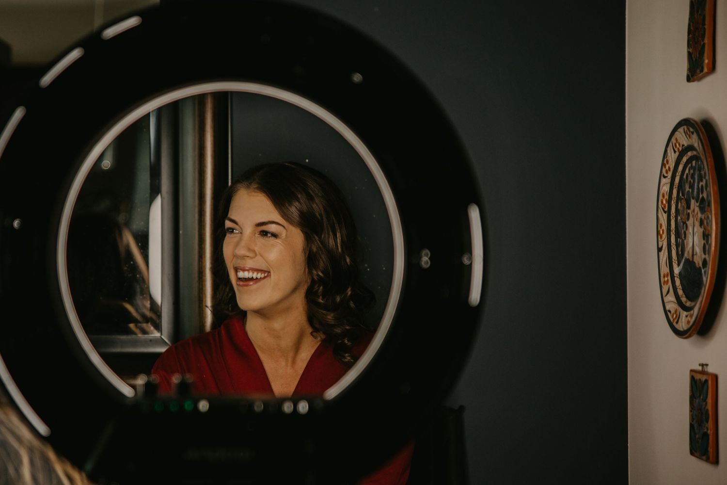 A vintage-style portrait through a circular mirror frame with warm lighting.