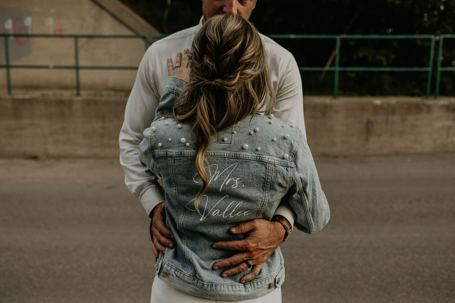 Close-up shot of couple embracing, showing denim jacket detail.