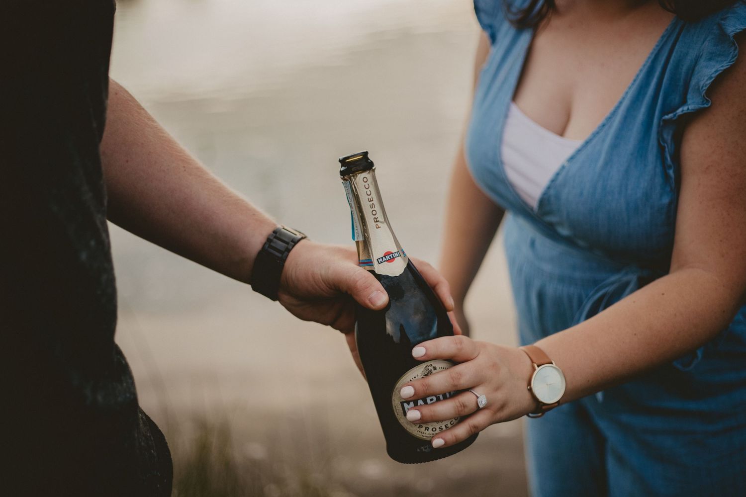 Two people sharing drinks together with a close-up of hands exchanging a bottled beverage.