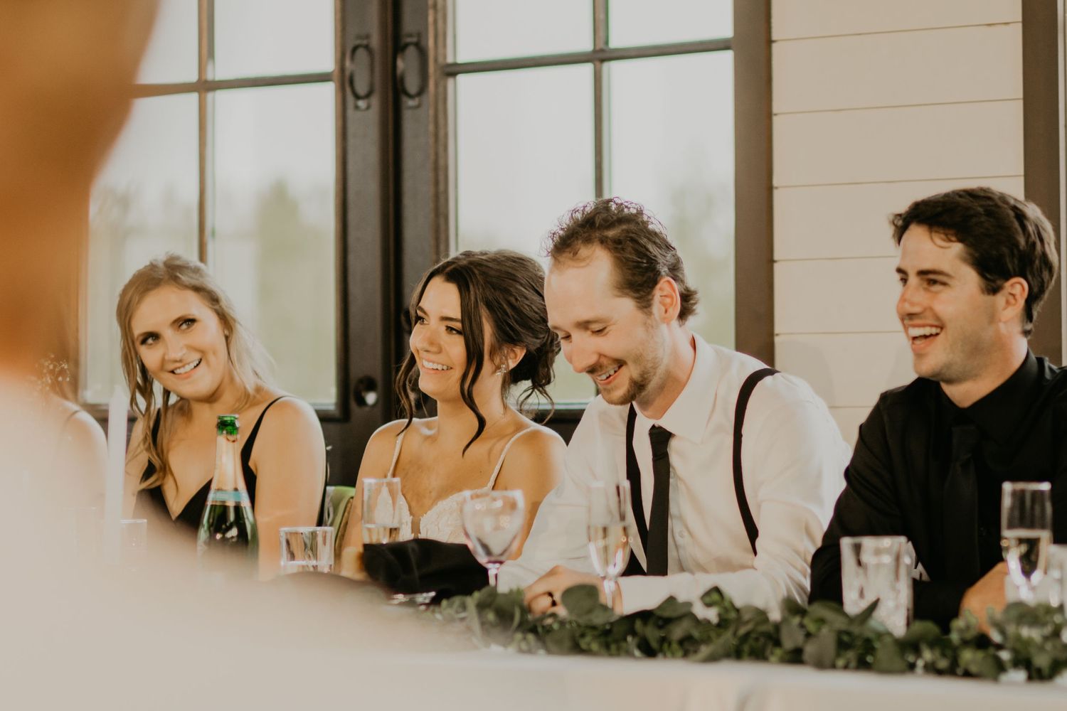Wedding party enjoying memorable moments at the reception head table.