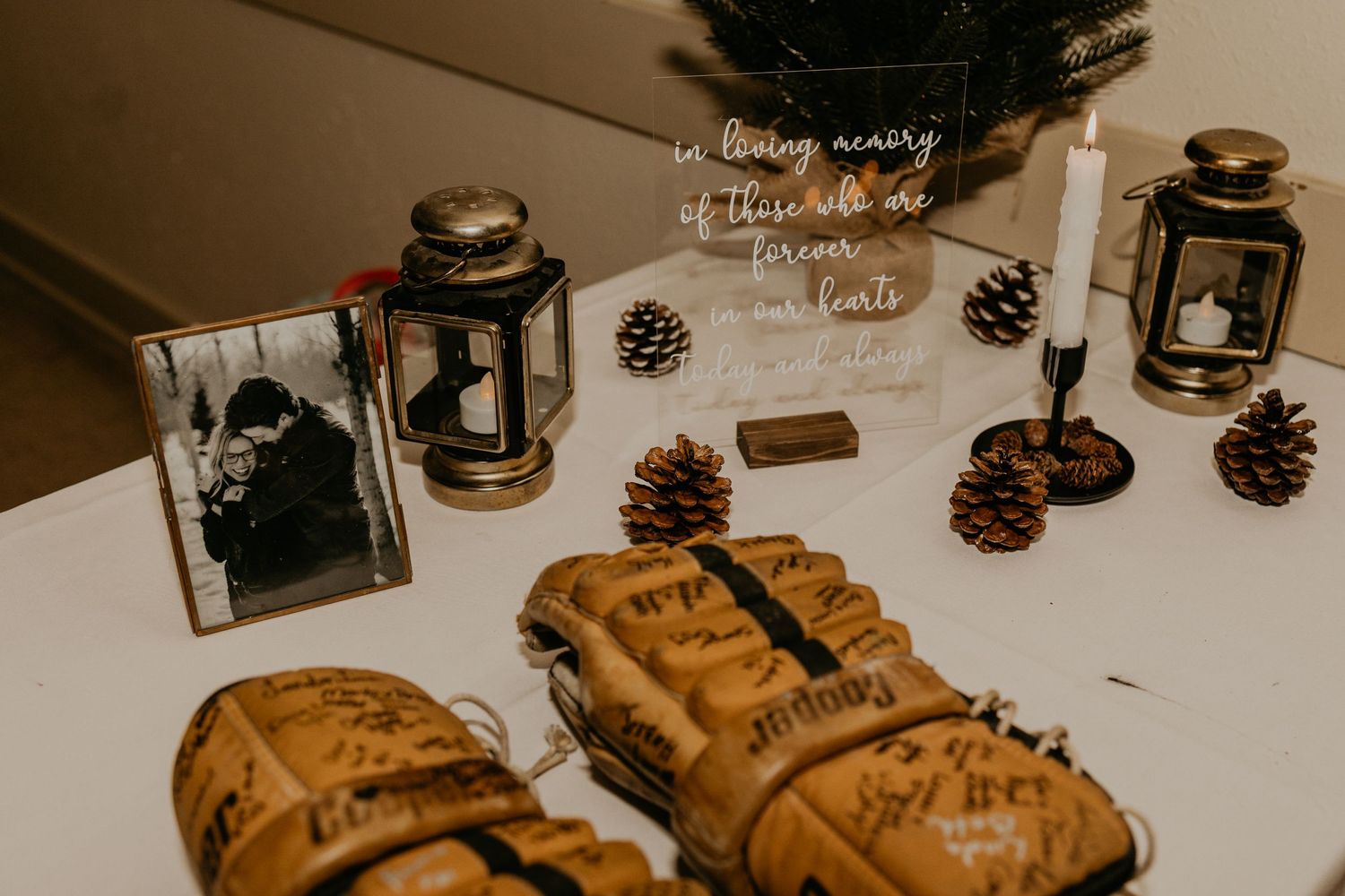 Rustic wedding table decor with lanterns, pinecones, and vintage frames.