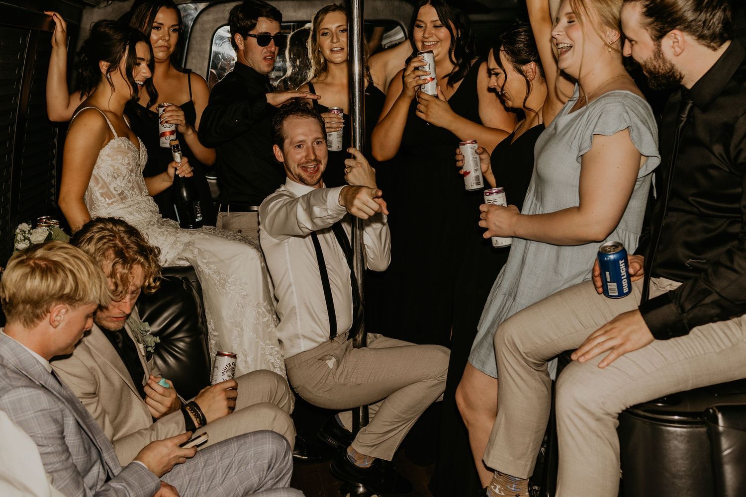 Wedding party celebrating and dancing in dimly lit party setting.