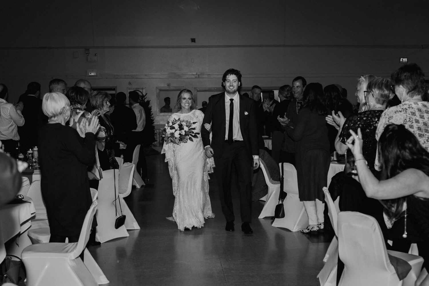 Wedding reception dance floor scene with guests celebrating in black and white photography.