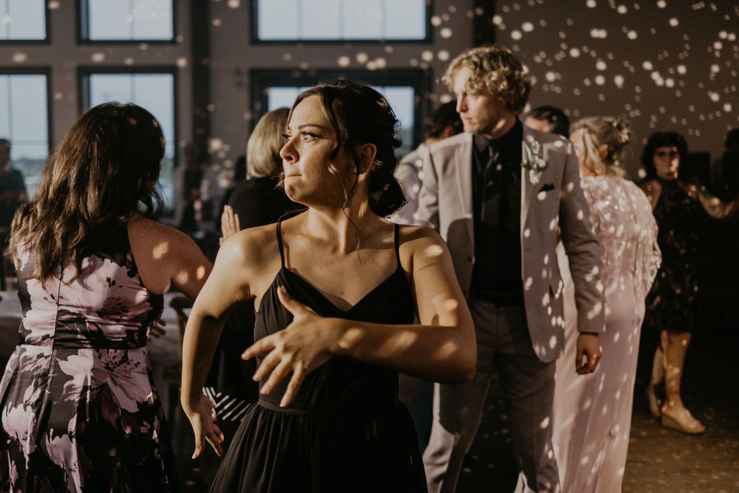 Wedding reception guests dancing under sparkly disco ball lighting.