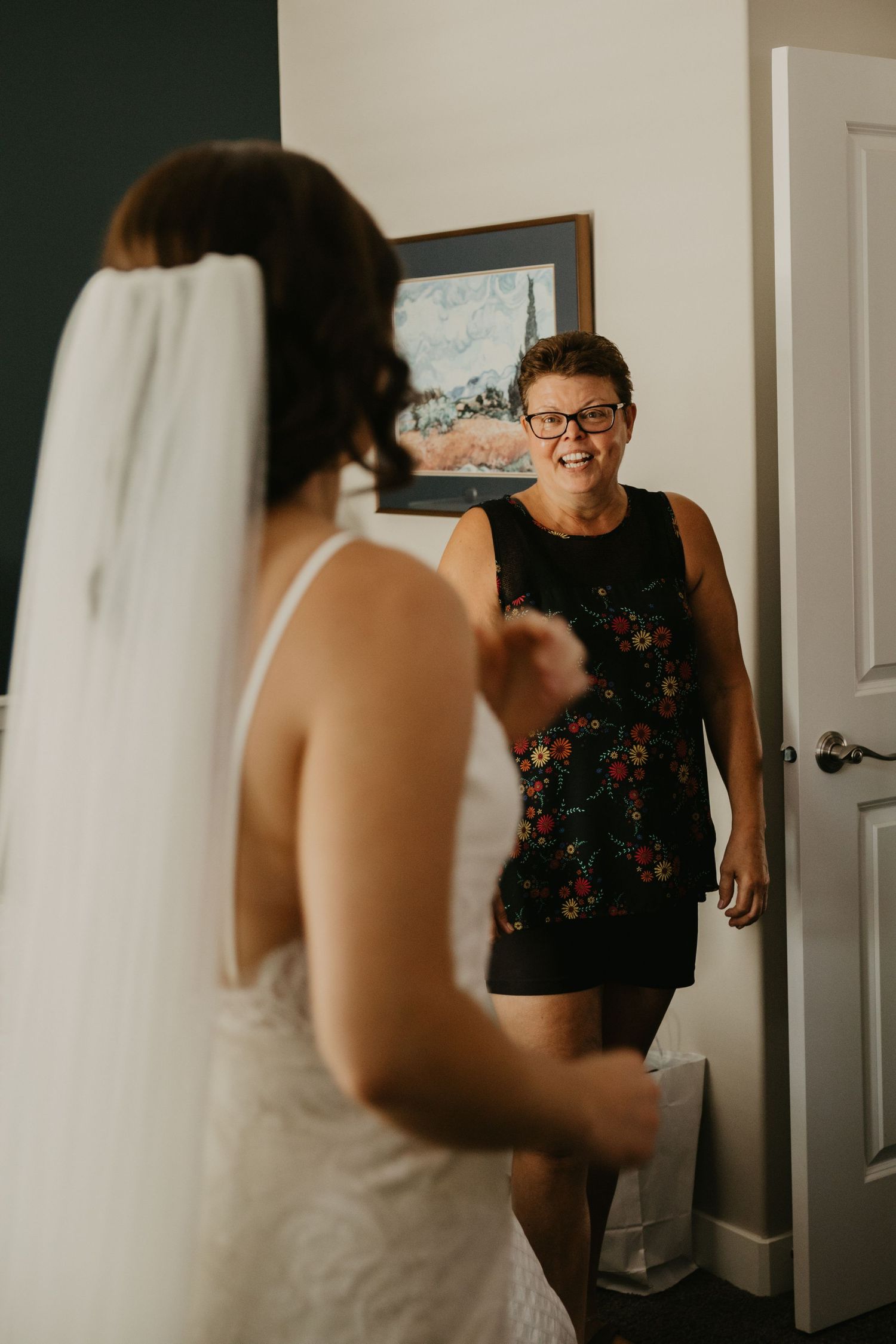A touching moment between a bride and loved one sharing expressions of joy on the wedding day.