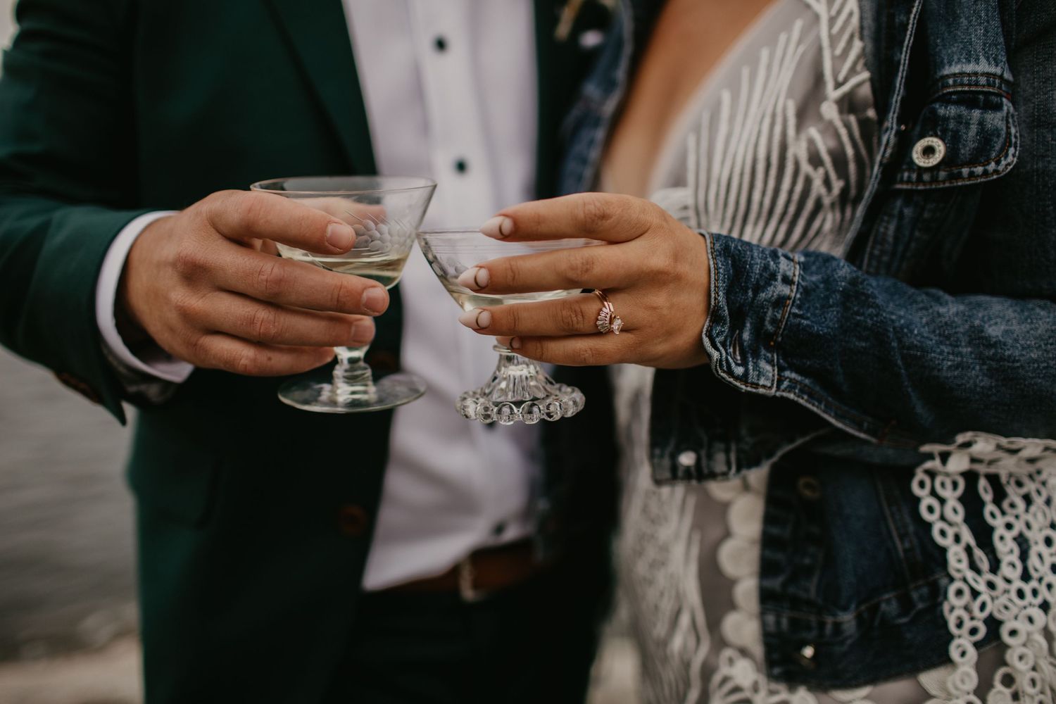 Close-up of hands holding champagne glasses during a wedding toast.