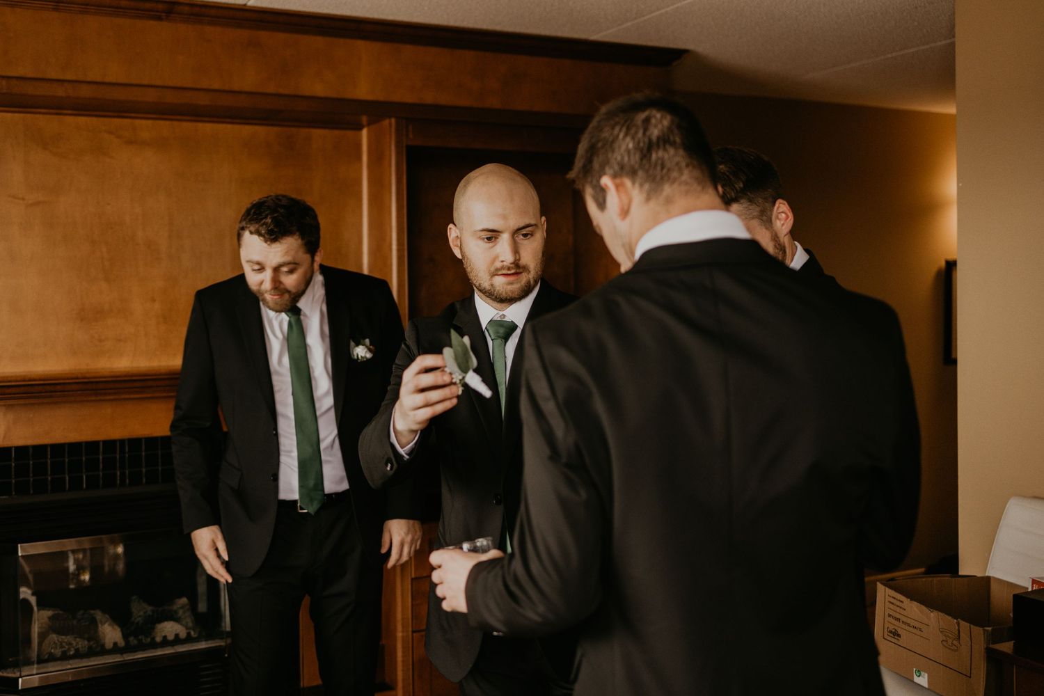 Wedding party in suits relaxing on couches during preparation.