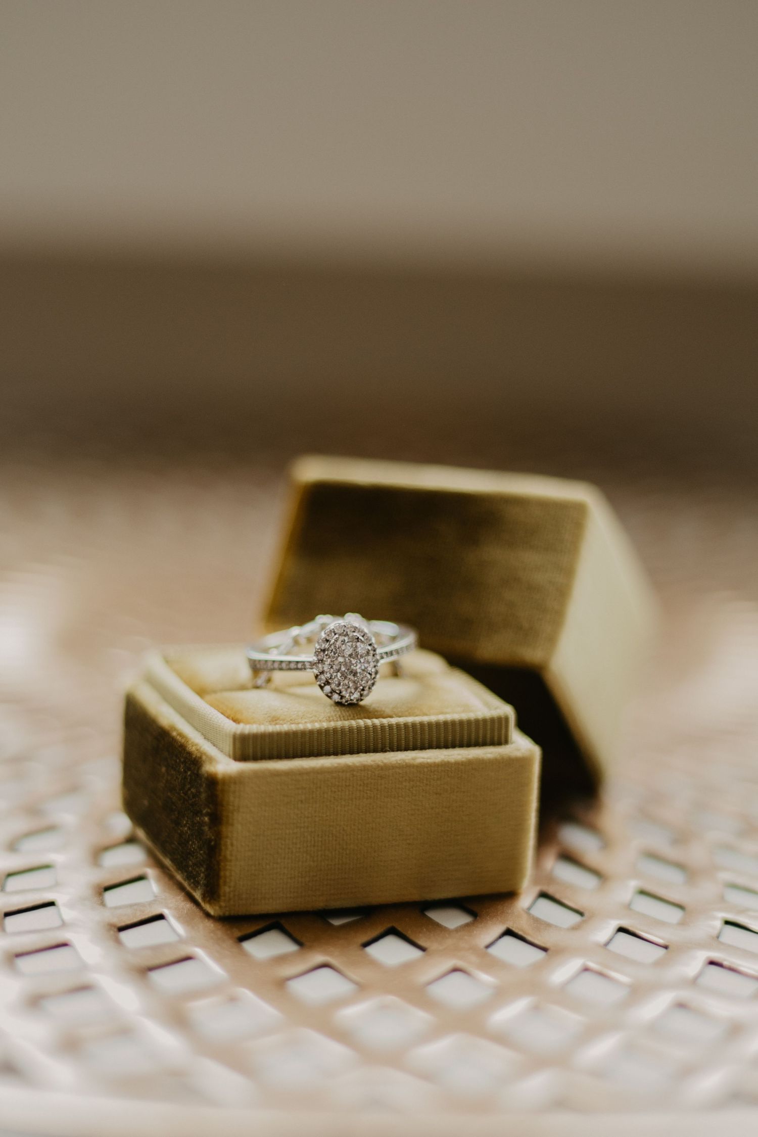 A stunning pear-shaped diamond engagement ring sits in a gold velvet ring box.