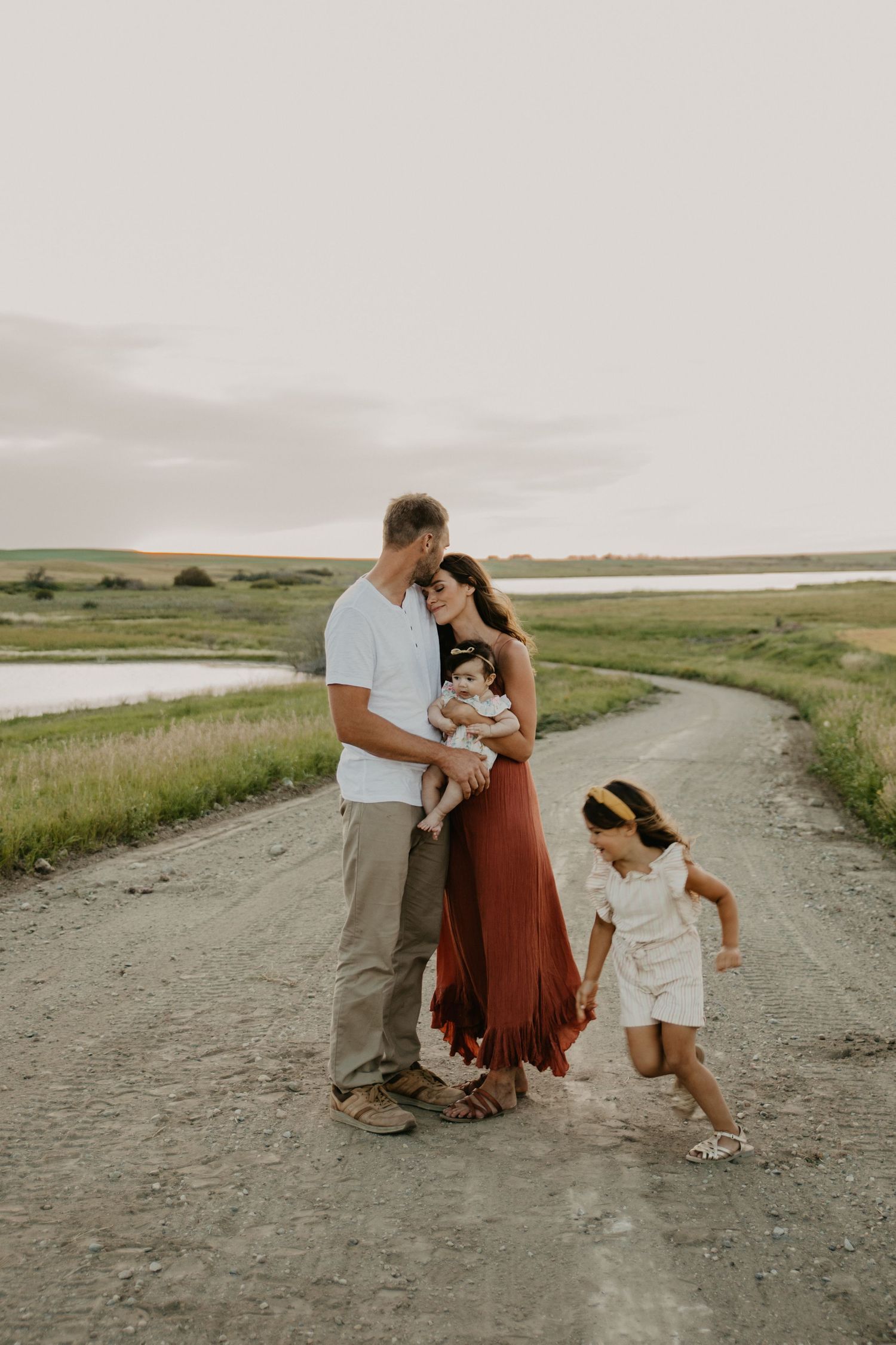 A family shares a special moment together on a winding dirt road at dusk.