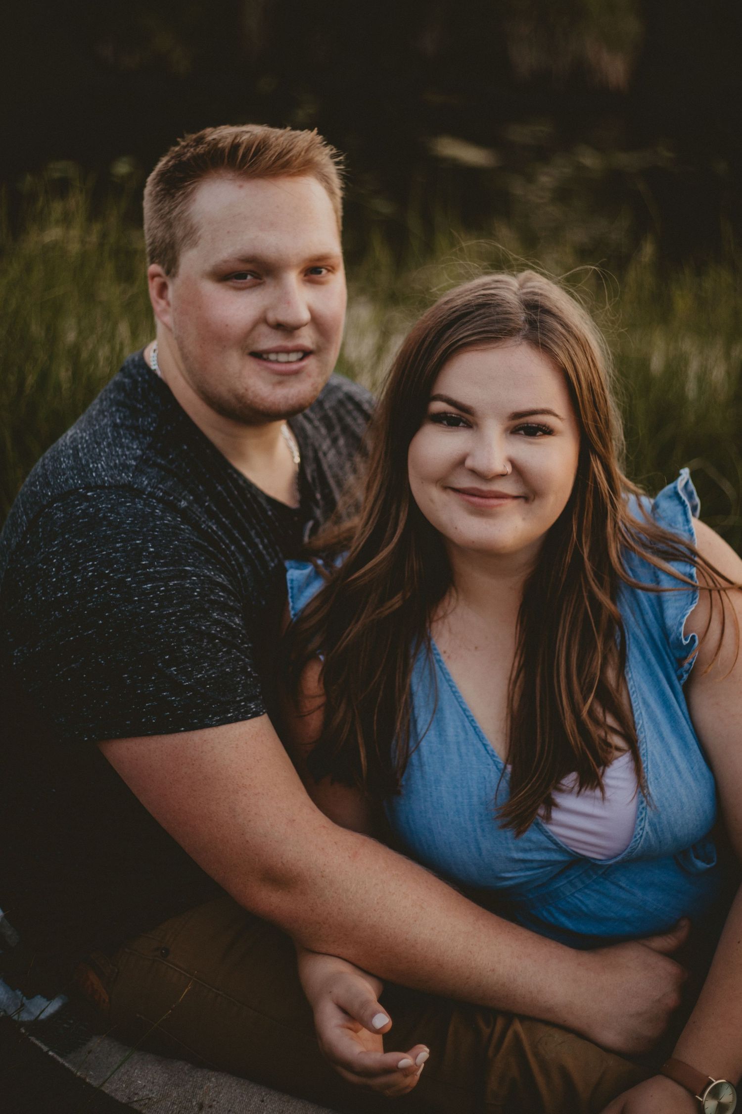An intimate outdoor portrait session at sunset with a couple in casual attire.