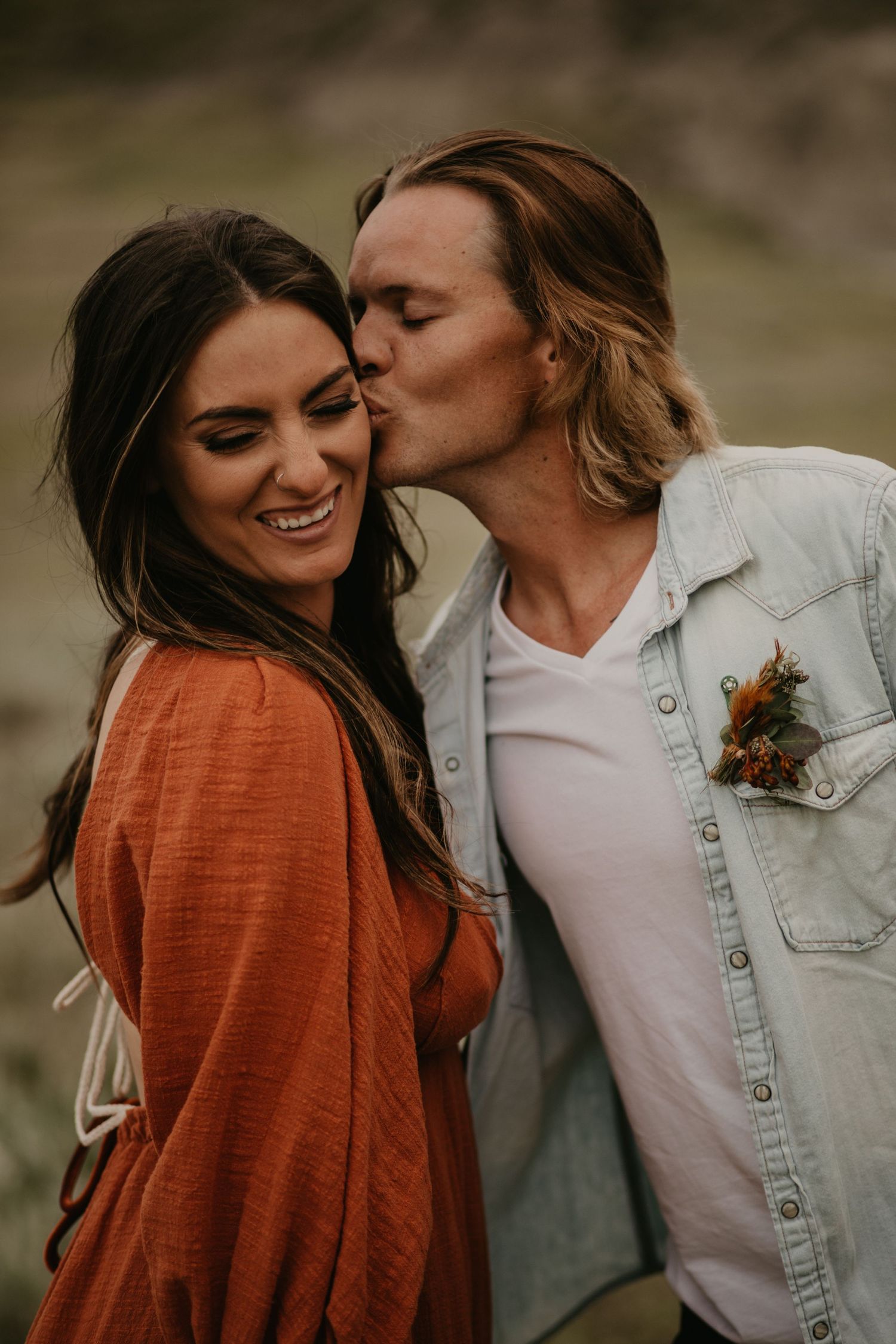 Intimate moment between couple in casual clothing against natural backdrop.