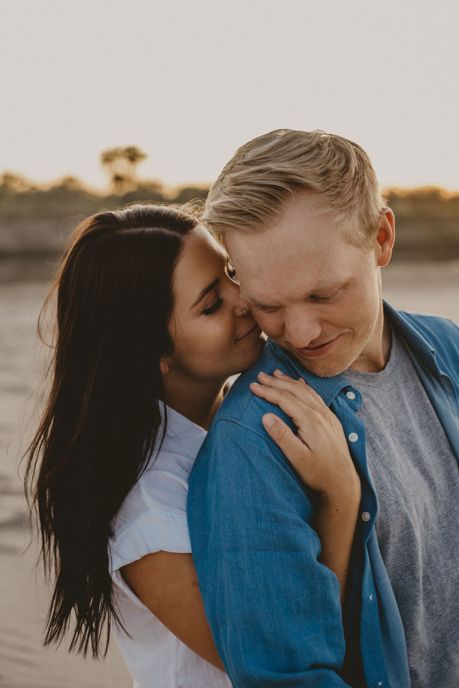 An intimate close-up portrait of a couple sharing a tender moment at sunset.