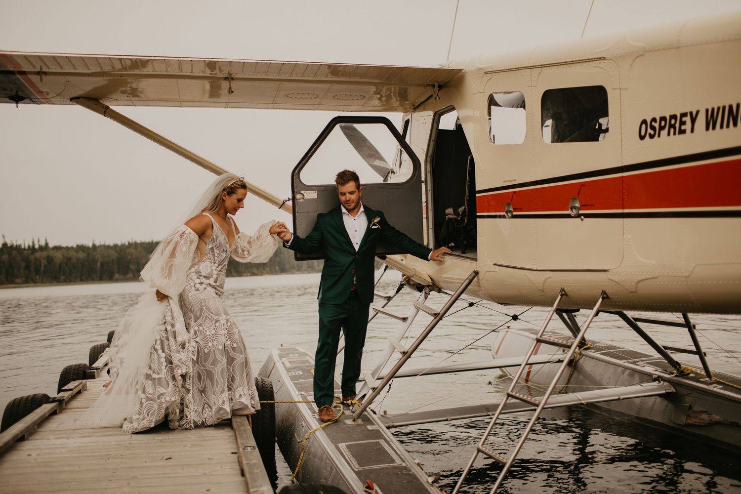 Wedding couple boarding a seaplane at wooden dock.