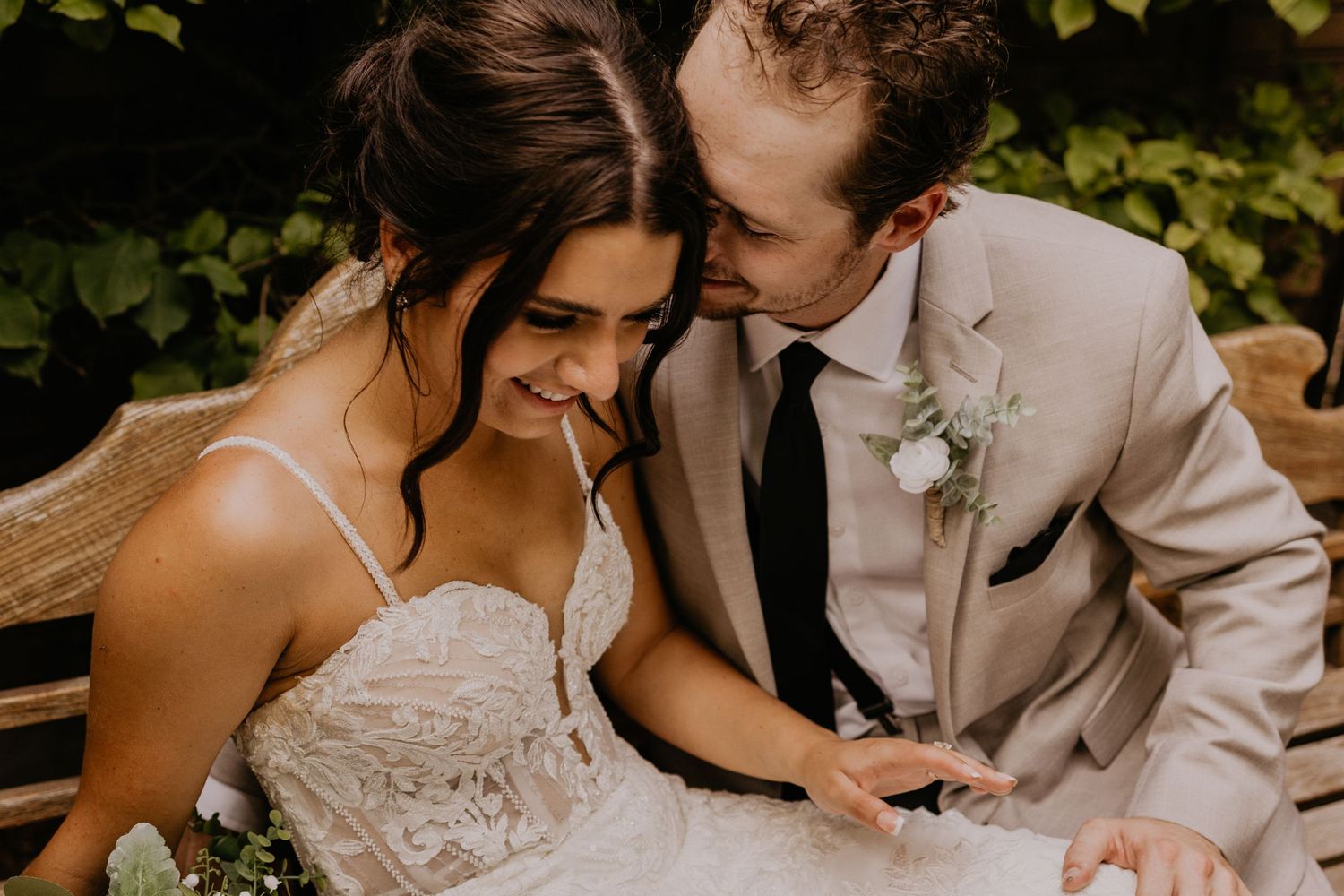Intimate moment between newlyweds sharing a tender moment outdoors in romantic lighting with floral details.