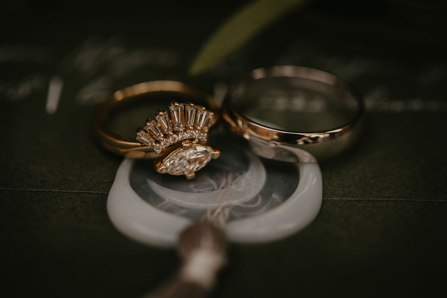 Elegant gold wedding rings with diamond detail on dark background.