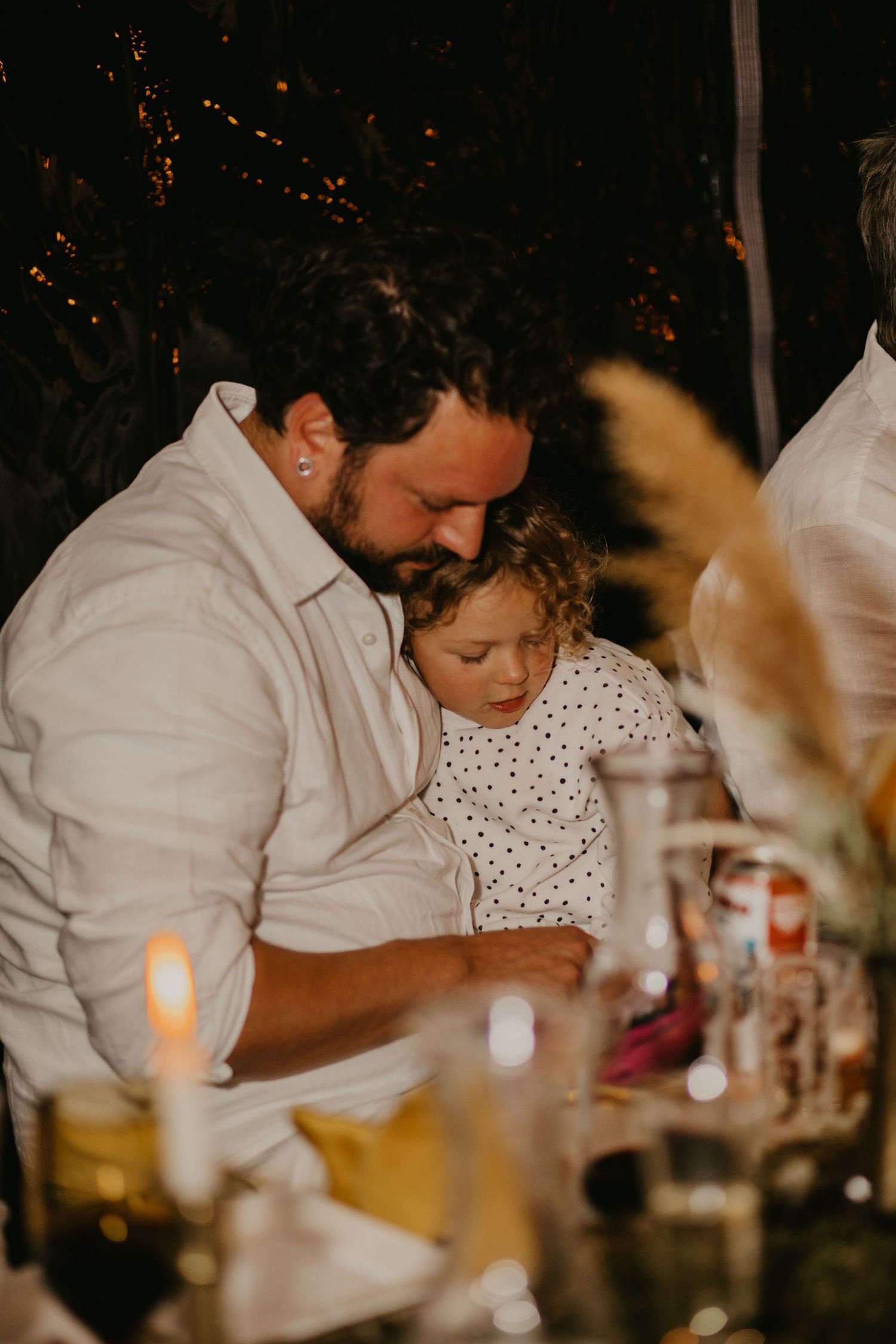 Heartwarming moment shared between parent and child during evening dinner celebration.