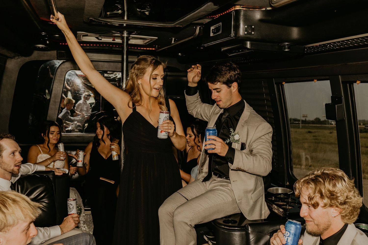 Guests enjoying lively celebration inside party bus with drinks and dancing.