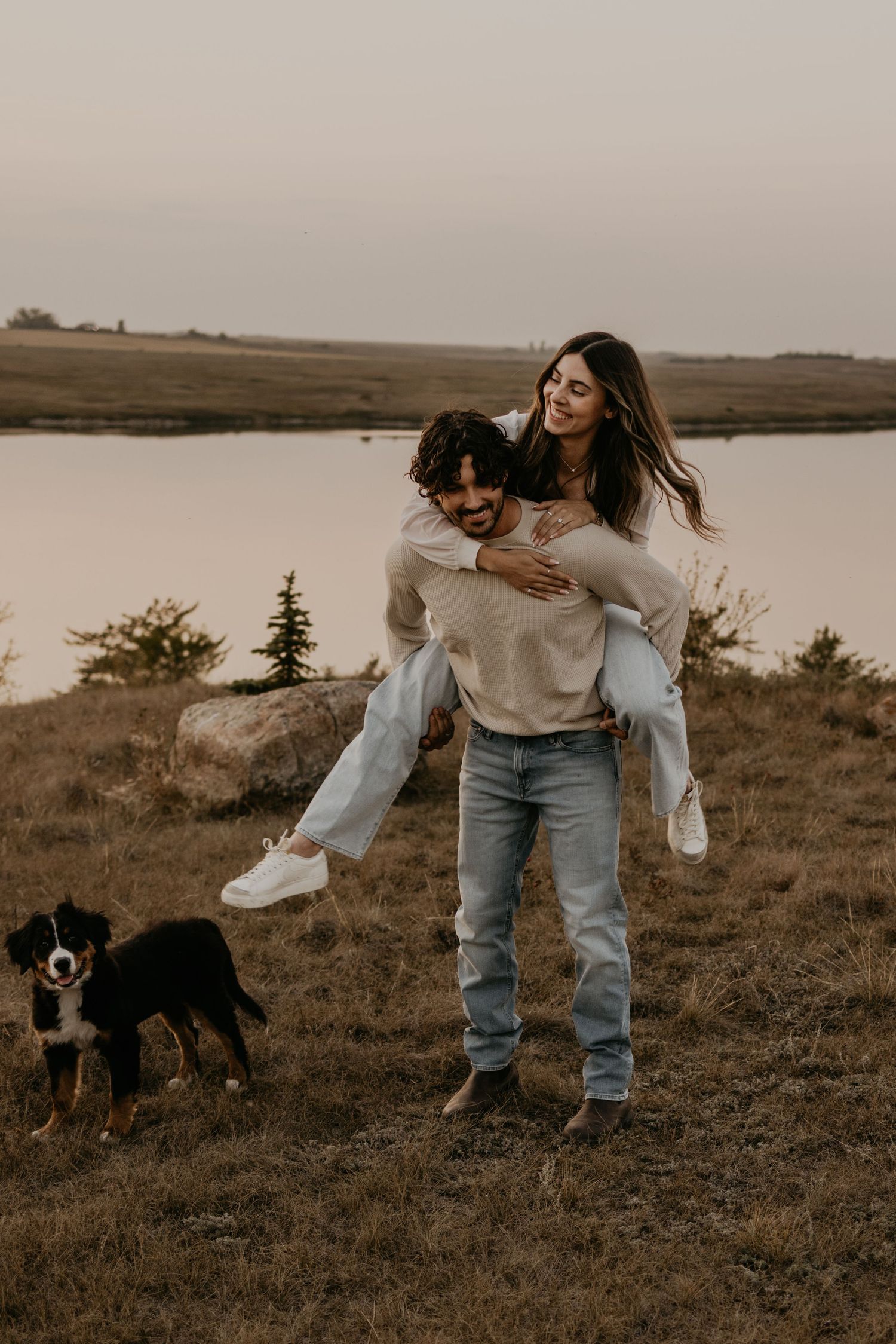 Playful piggyback ride moment with a dog companion in a serene outdoor setting at dusk.