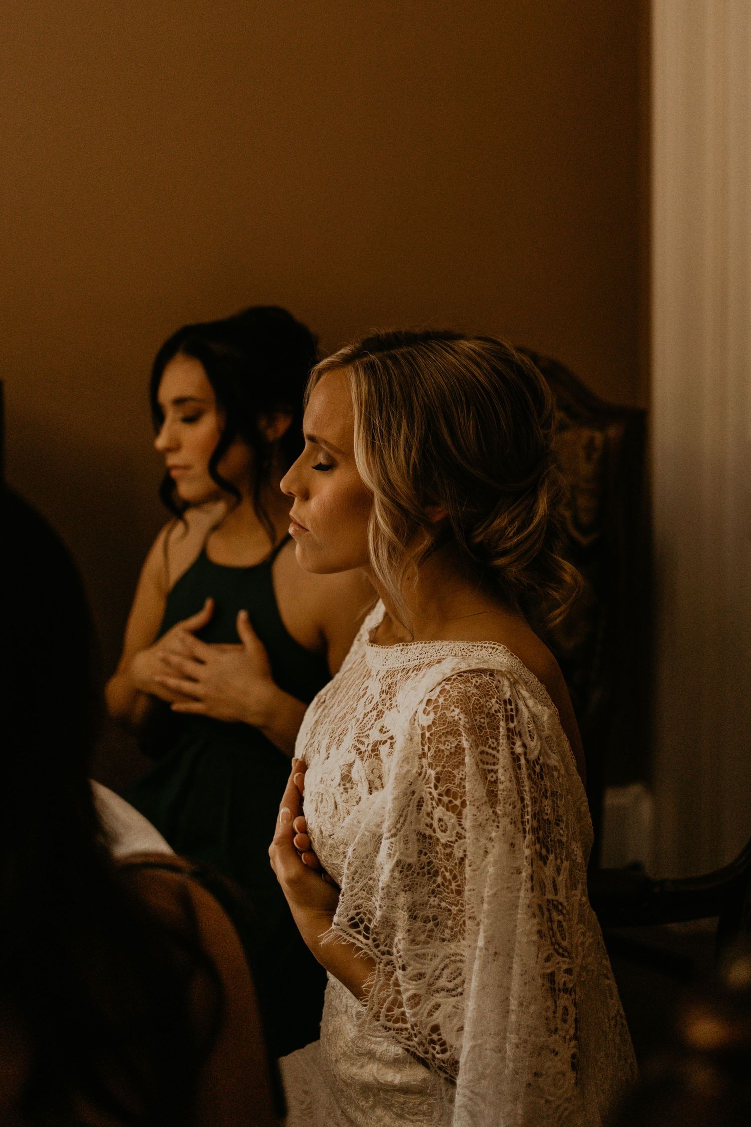 Wedding preparations in a warm-toned room with formal attire and lace details.