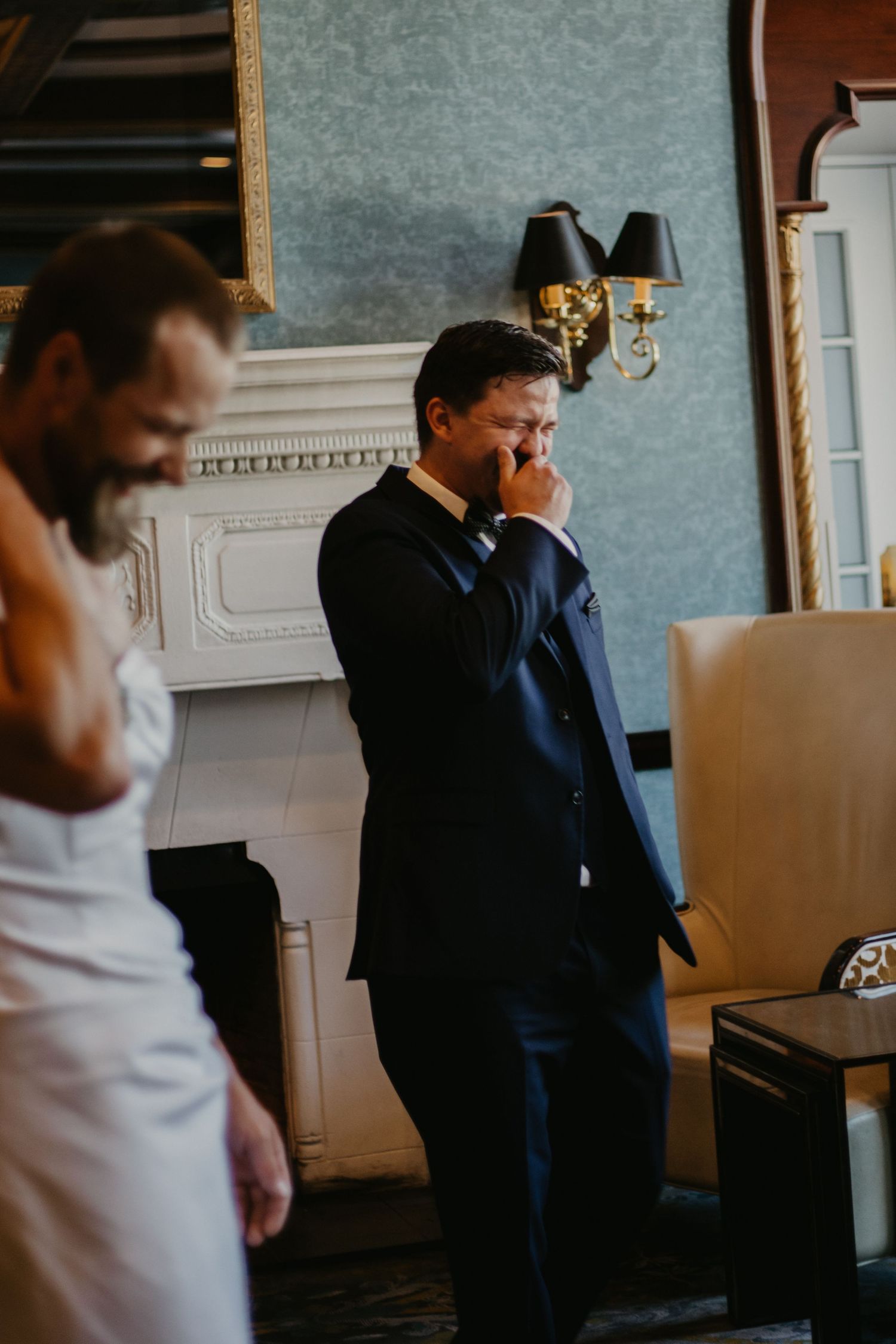 Emotional wedding moment captured in an elegant room with classic decor.