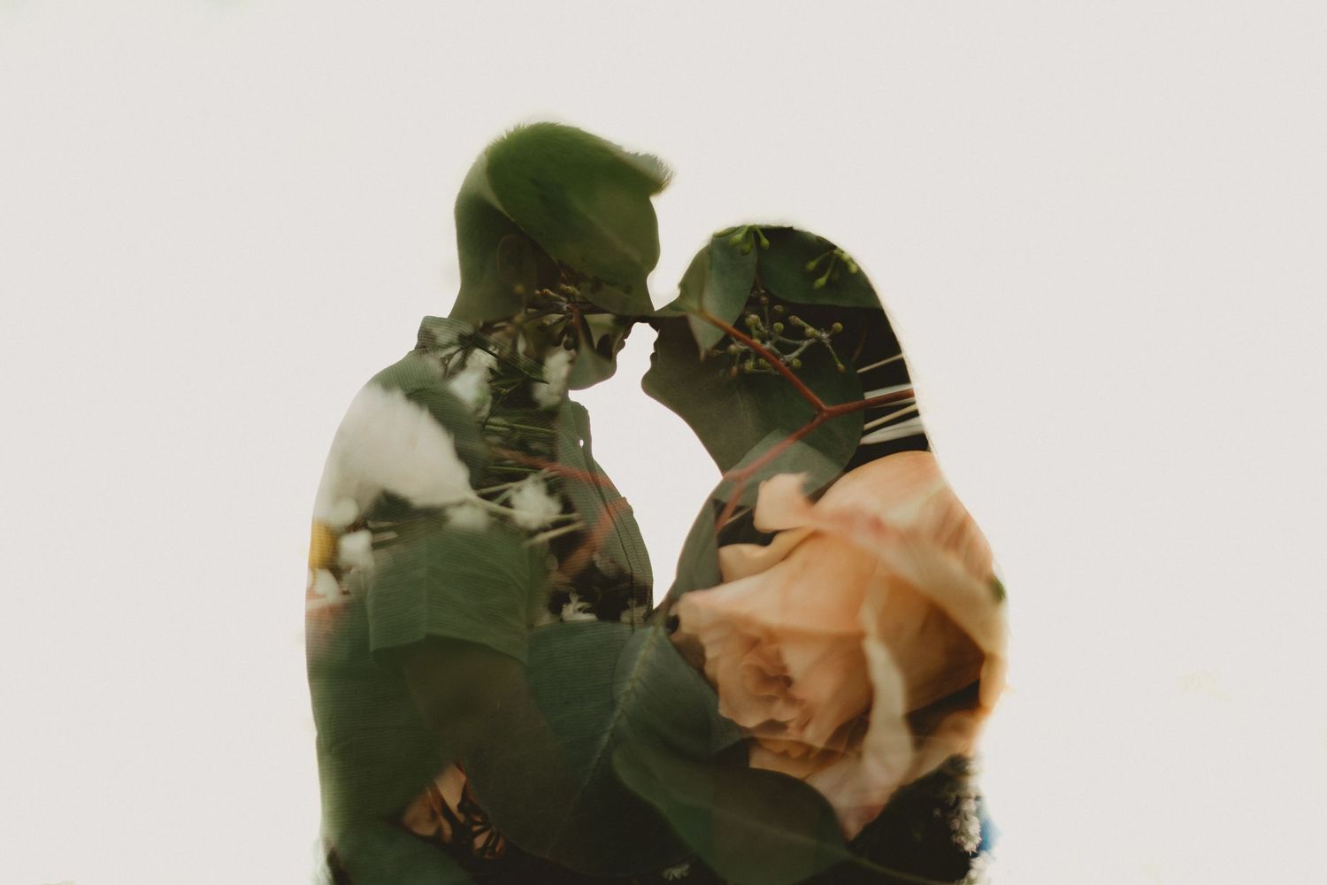 A double exposure portrait combining a couple's silhouette with delicate rose petals.