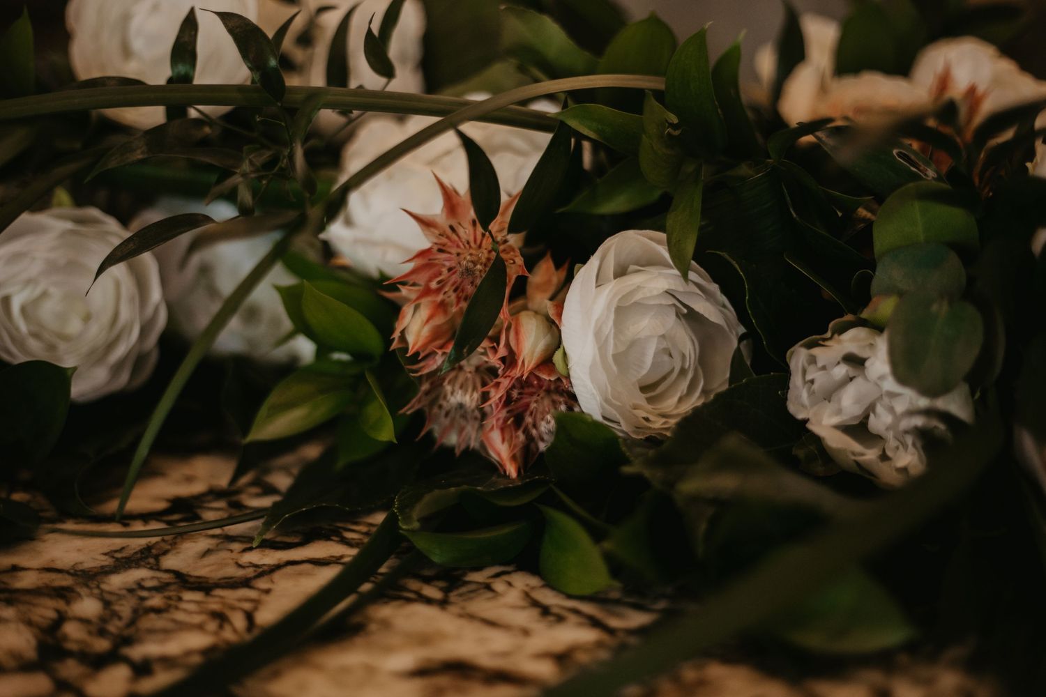Soft focus shot of white roses and dried flowers in romantic wedding arrangement.
