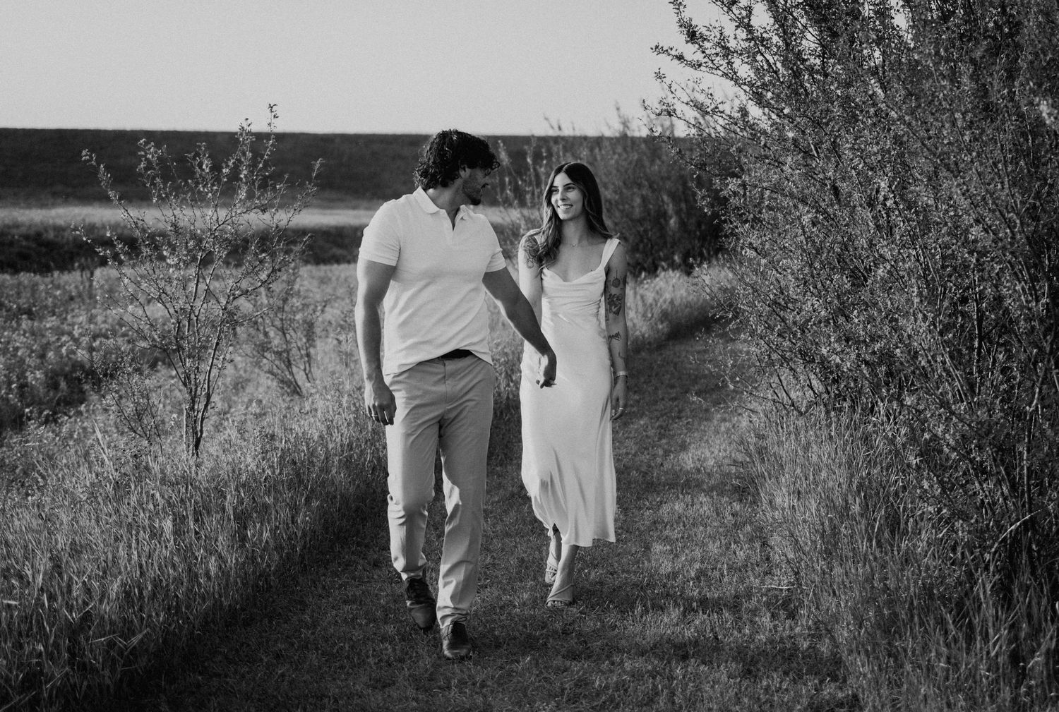 Black and white photograph showing silhouettes walking together through a rustic outdoor setting.