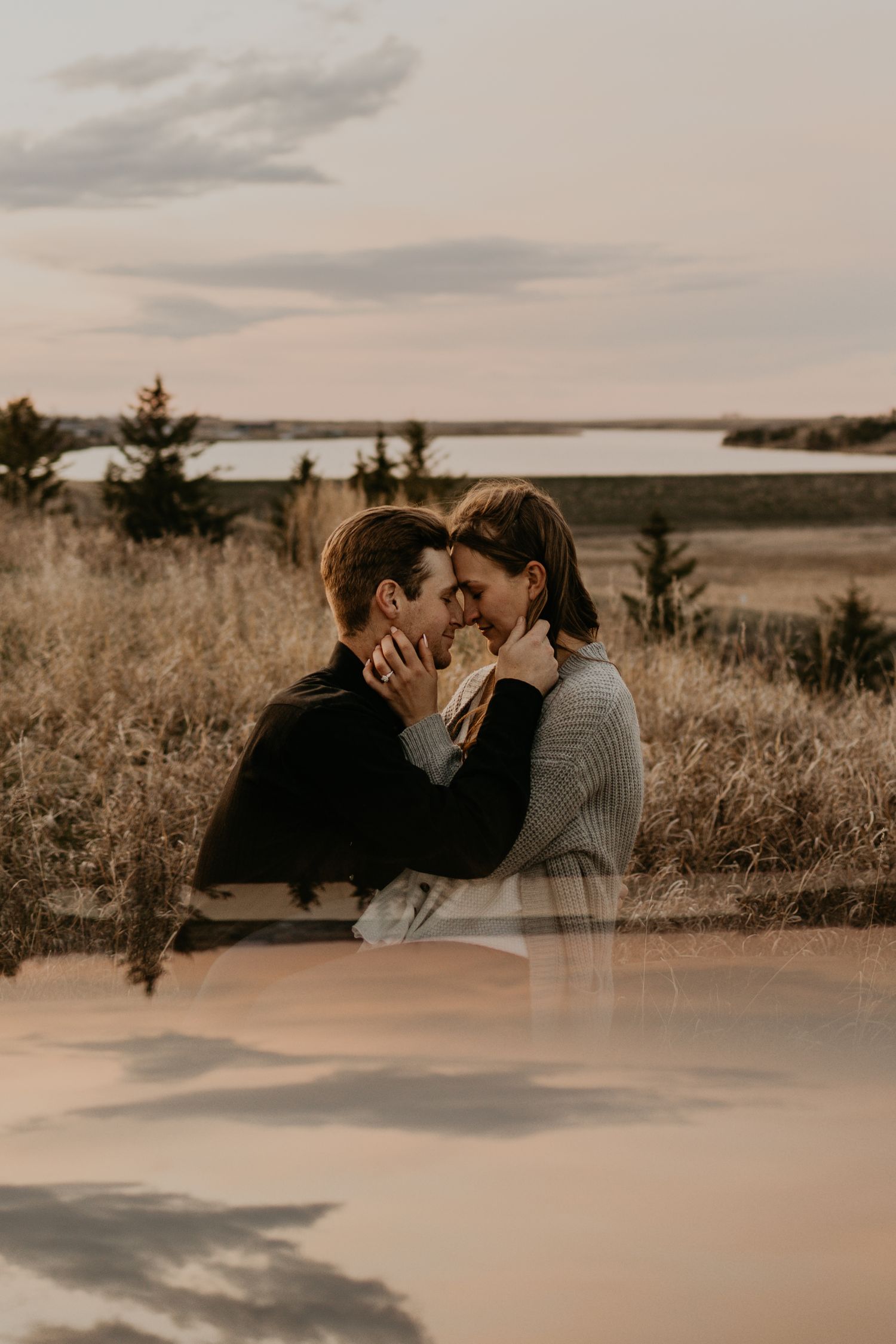 Intimate moment captured at sunset overlooking serene lake and pine trees.